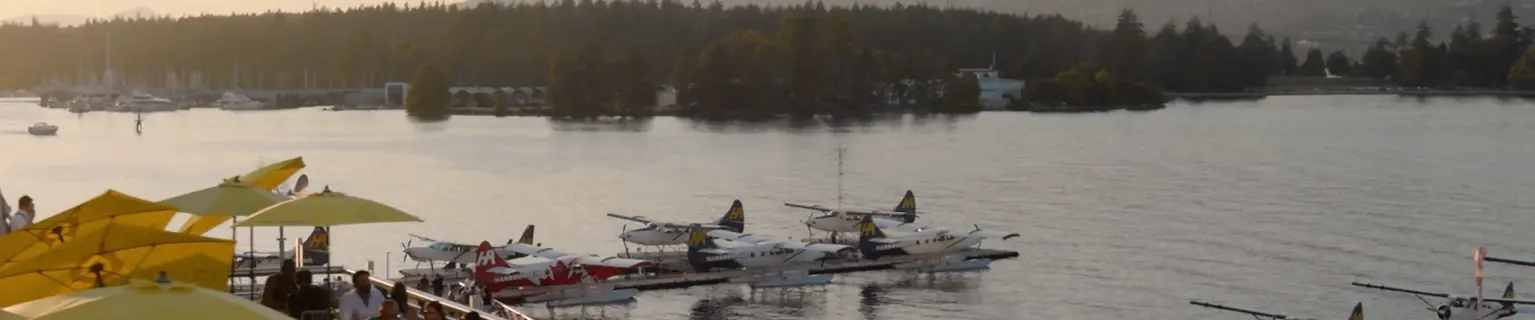 Coal Harbour at sunset with docks, boats and soft mountains behind
