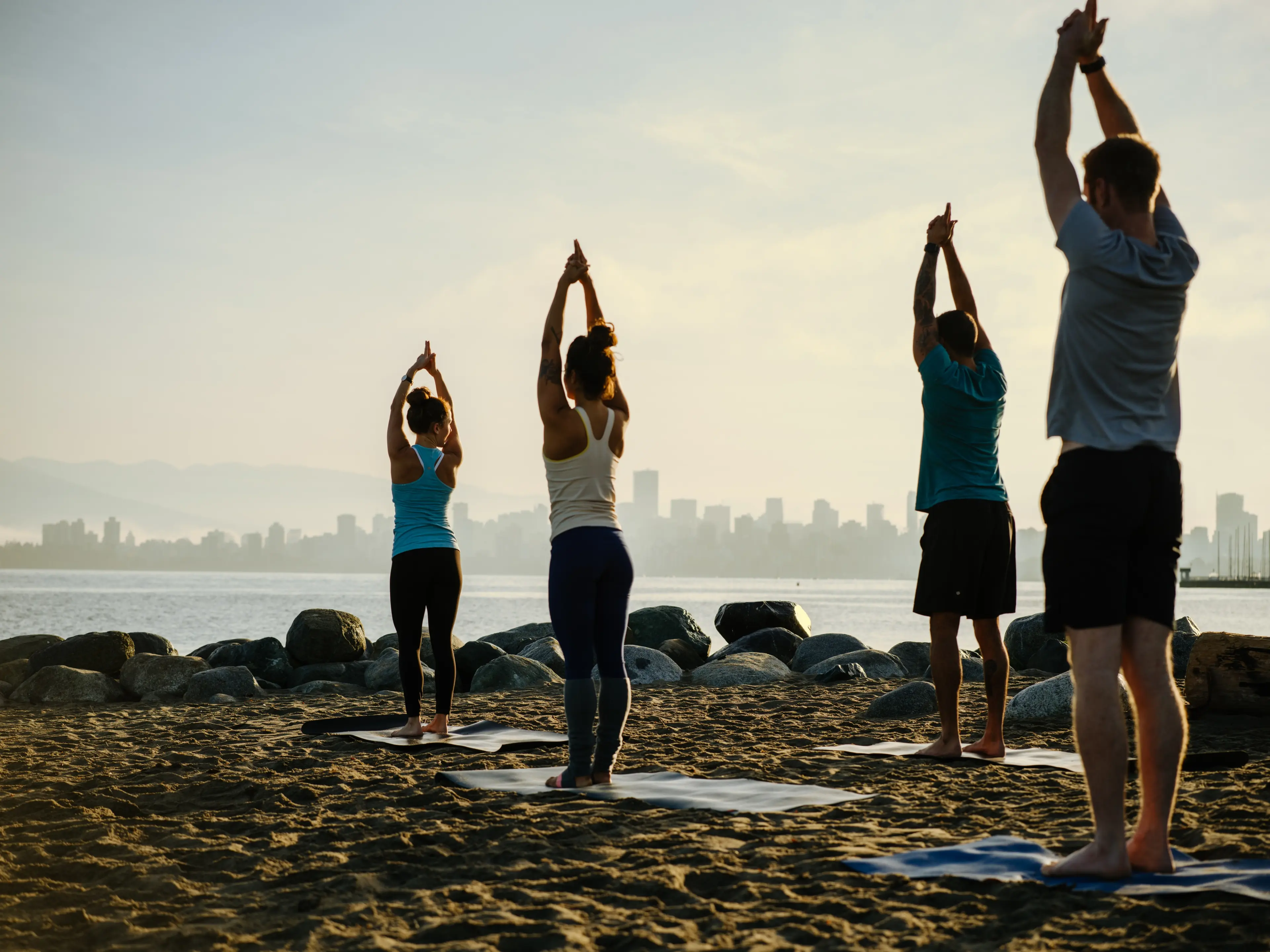 A group of people practicing yoga on a beach
