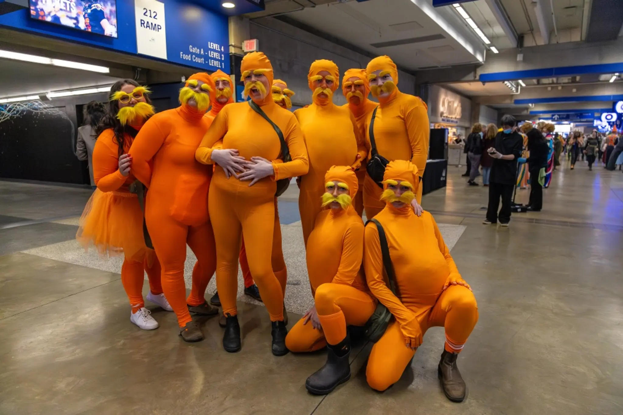 People dressed in orange costumes to attend a rugby game