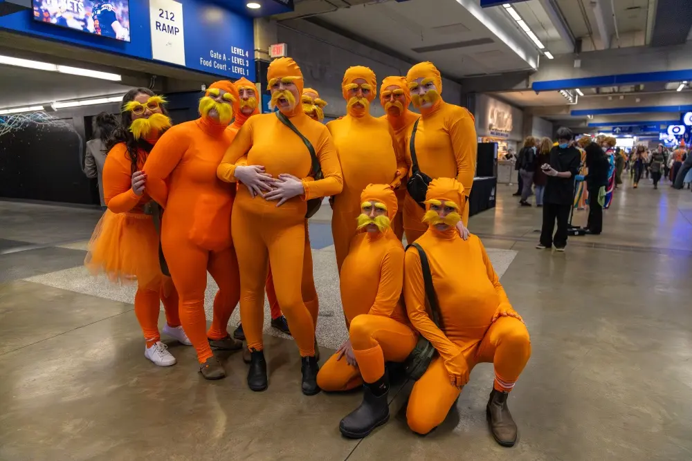 People dressed in orange costumes to attend a rugby game