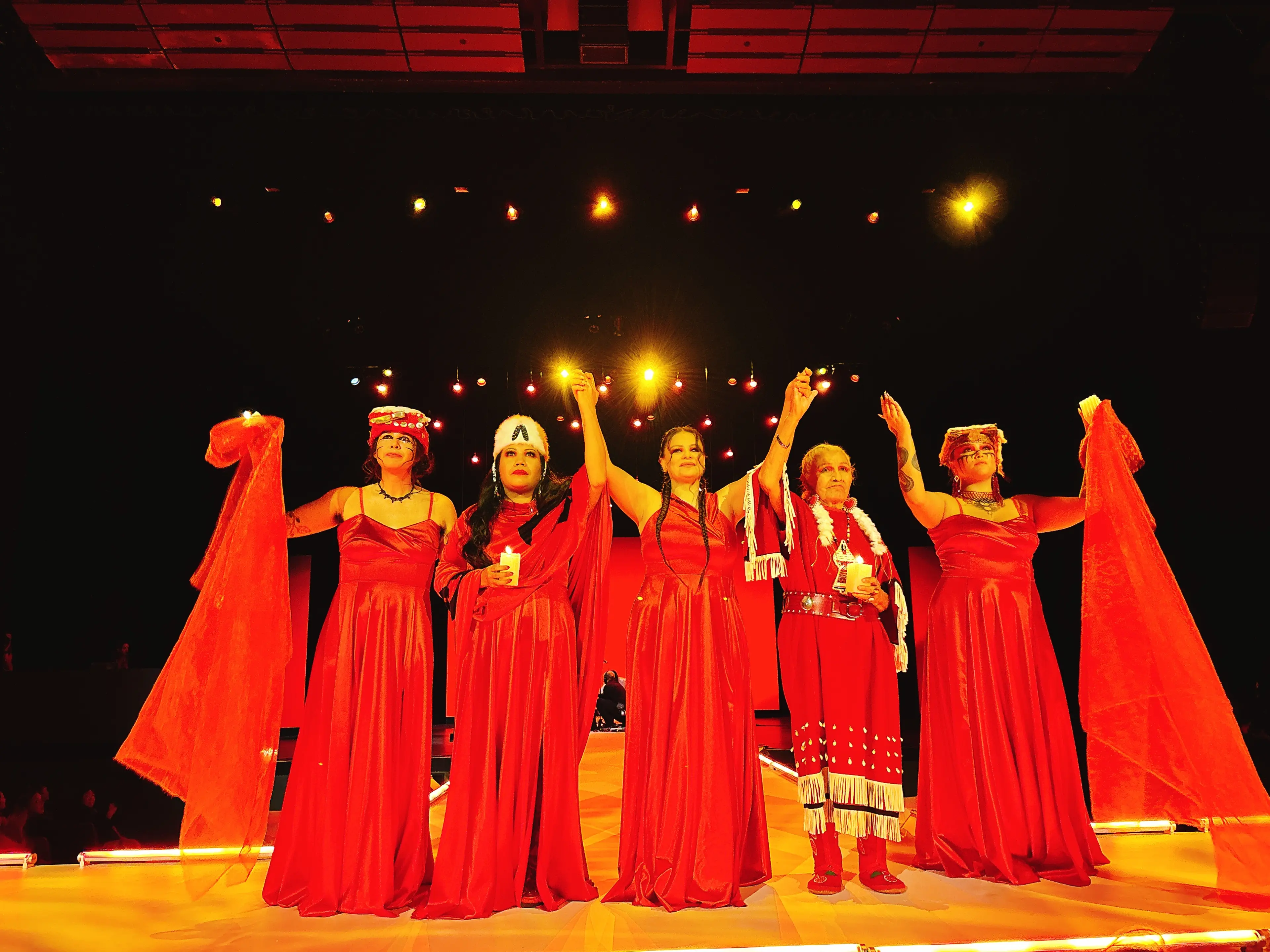 Dancers hold raised hands after Red Spirit Dance during VIFW