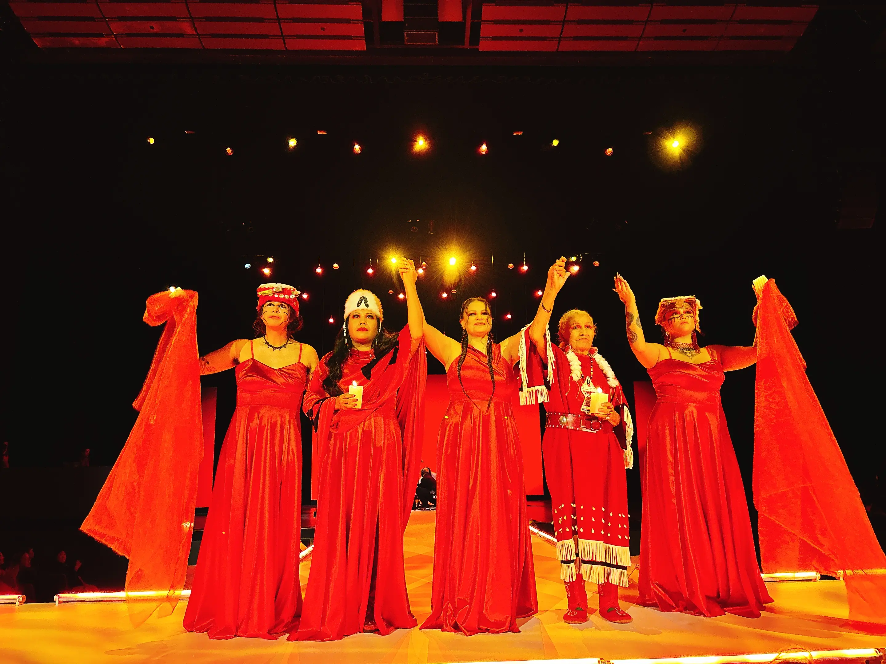 Dancers hold raised hands after Red Spirit Dance during VIFW
