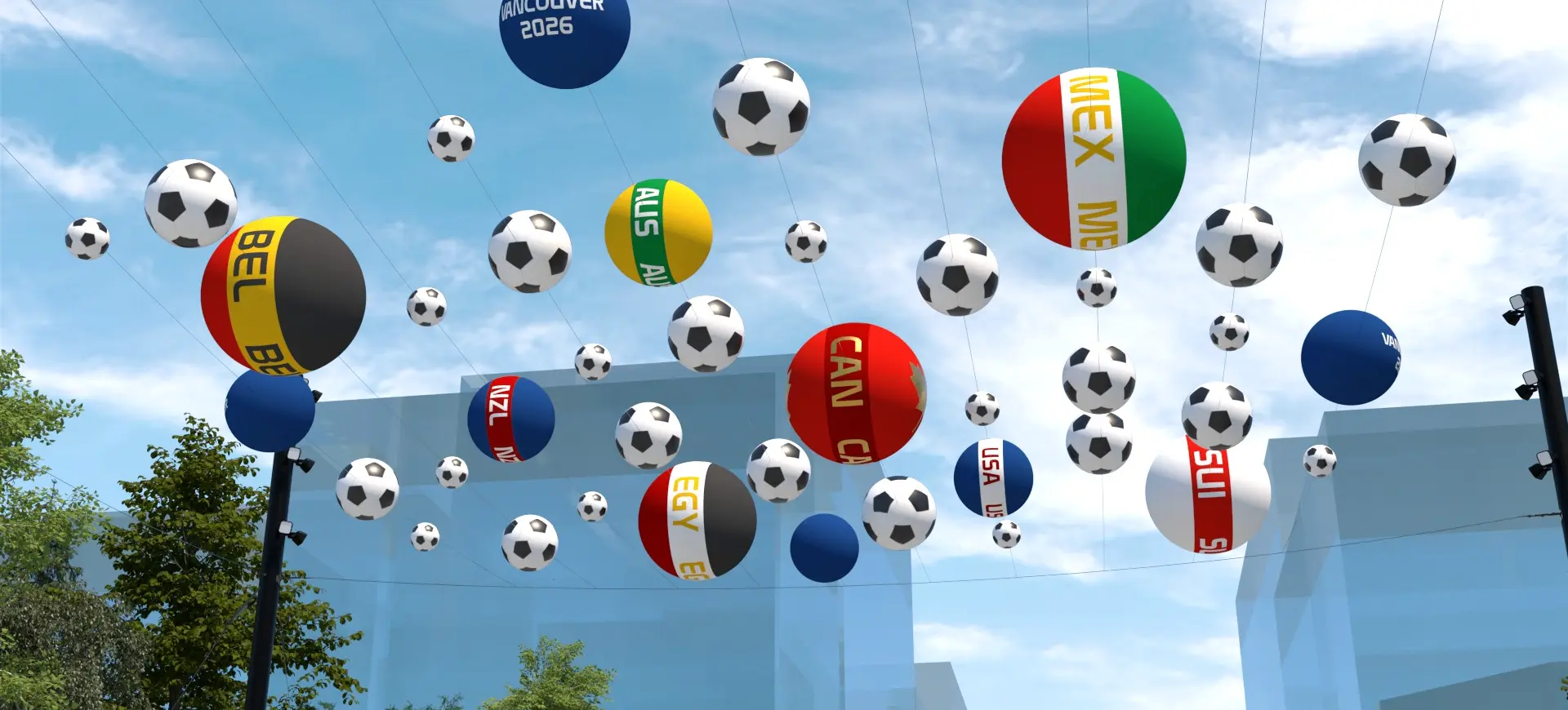 Numerous balloons shaped like soccer balls and country flags floating in the sky above buildings and trees.
