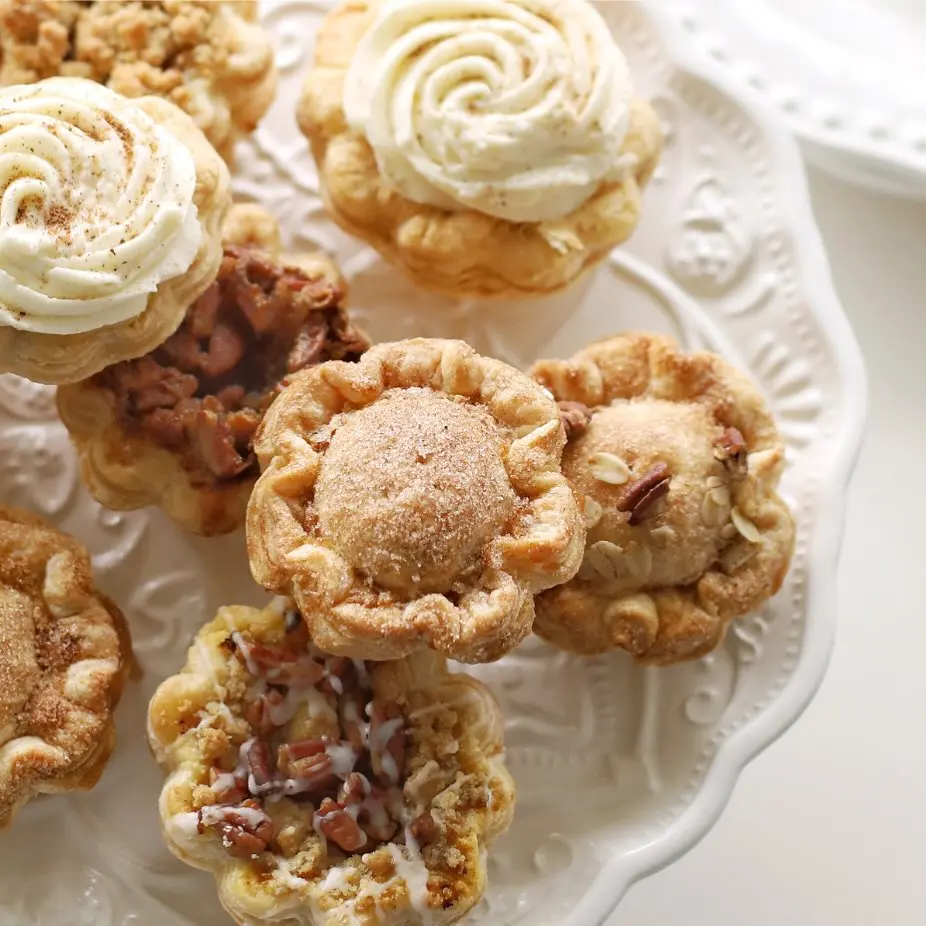 A group of mini holiday pies from The Pie Hole arranged on a white plate.