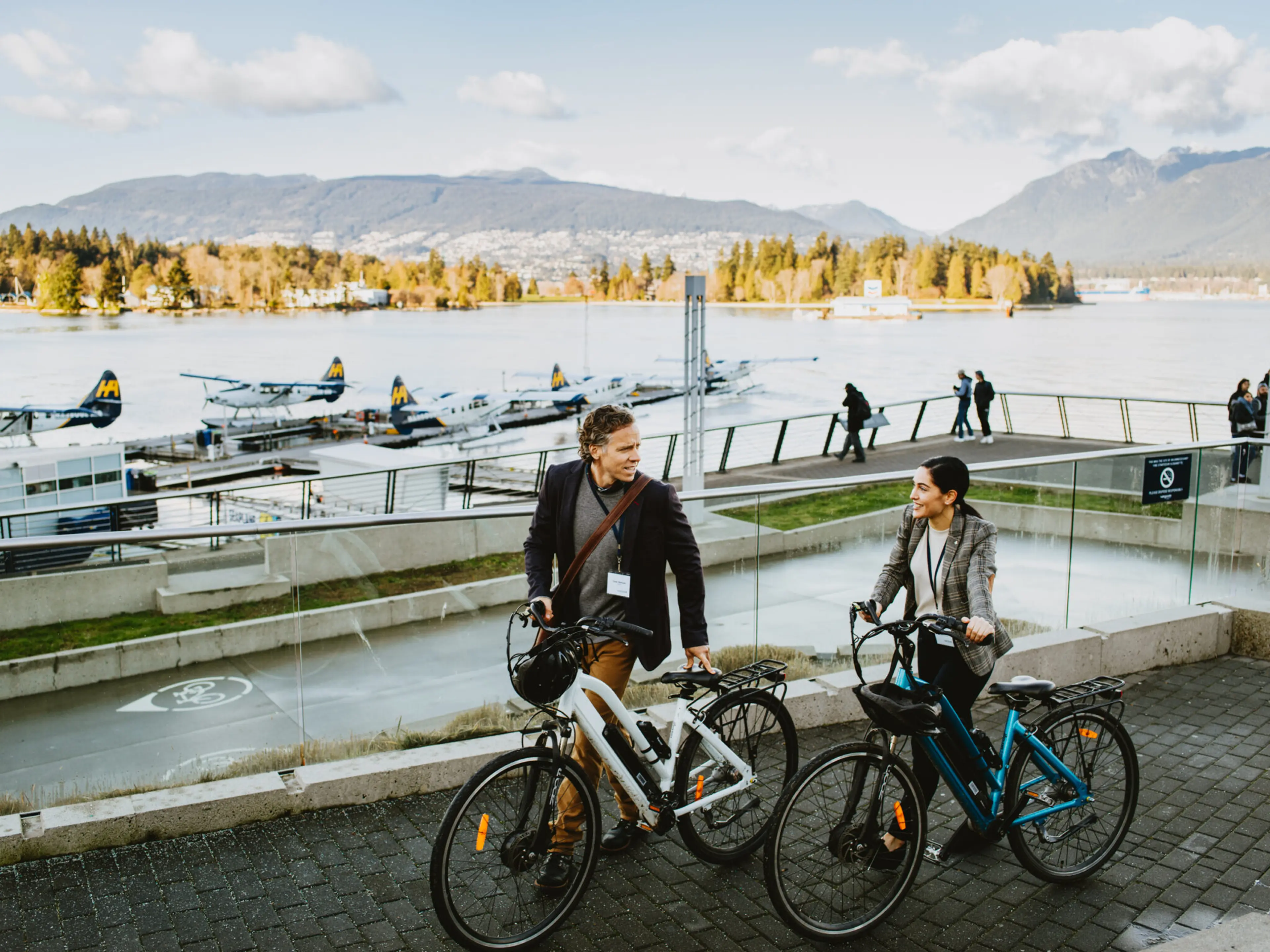 Two people e-biking on the Coal Harbour Seawall in Vancouver