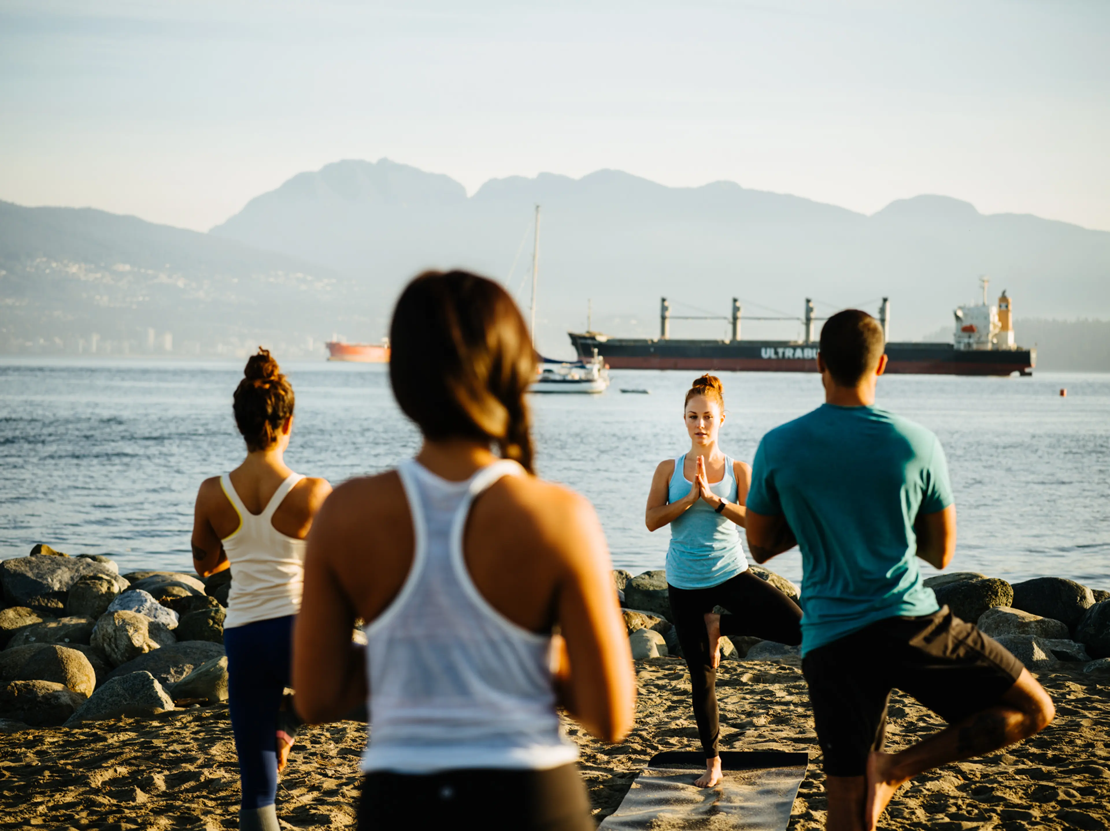 People doing yoga on a beach in Vancouver