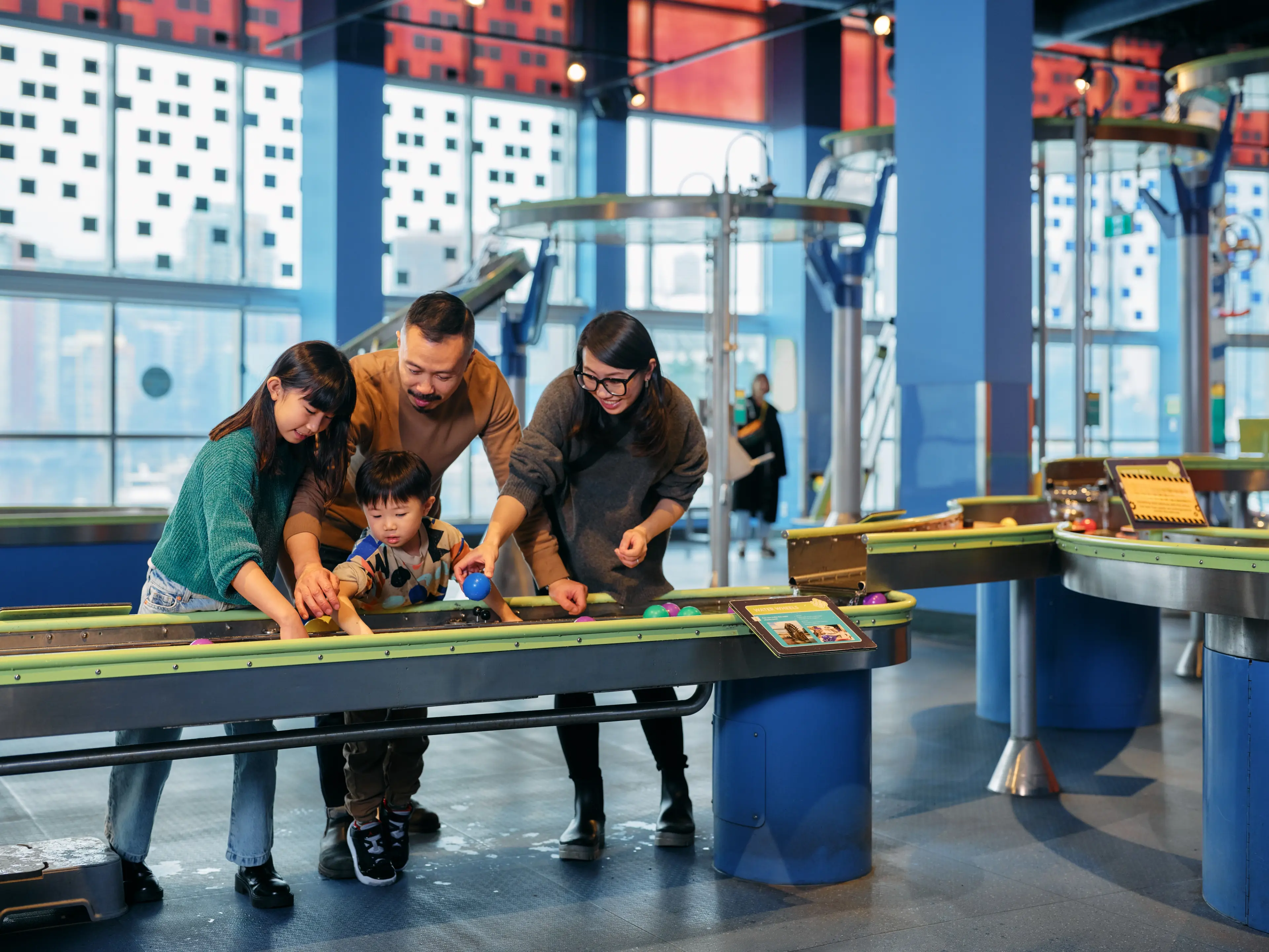 A family with two kids standing around an interactive play area at the Science World in Vancouver.
