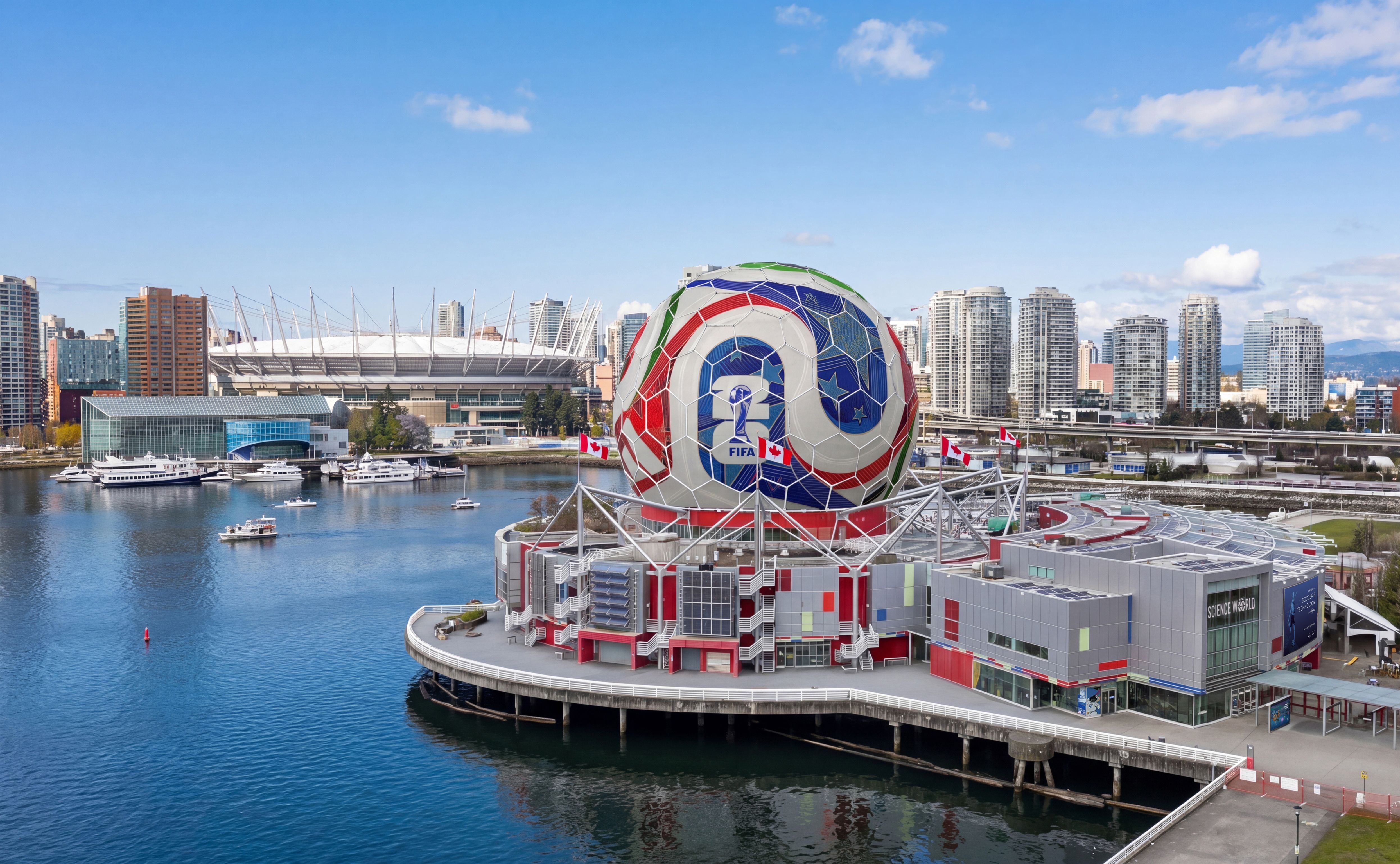 Large spherical structure decorated like a soccer ball with FIFA logo on a waterfront building, city skyline in background.