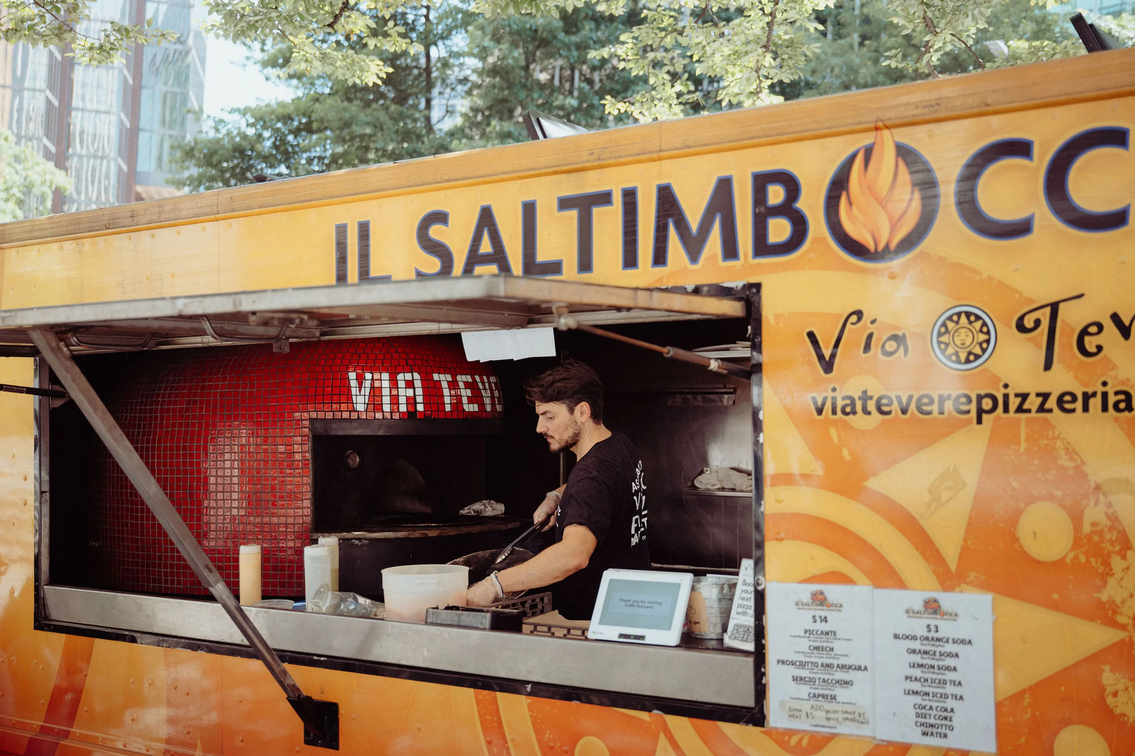 Chef preparing authentic Italian street food in a wood fired oven inside the Il Saltimbocca food truck, parked in downtown Vancouver.