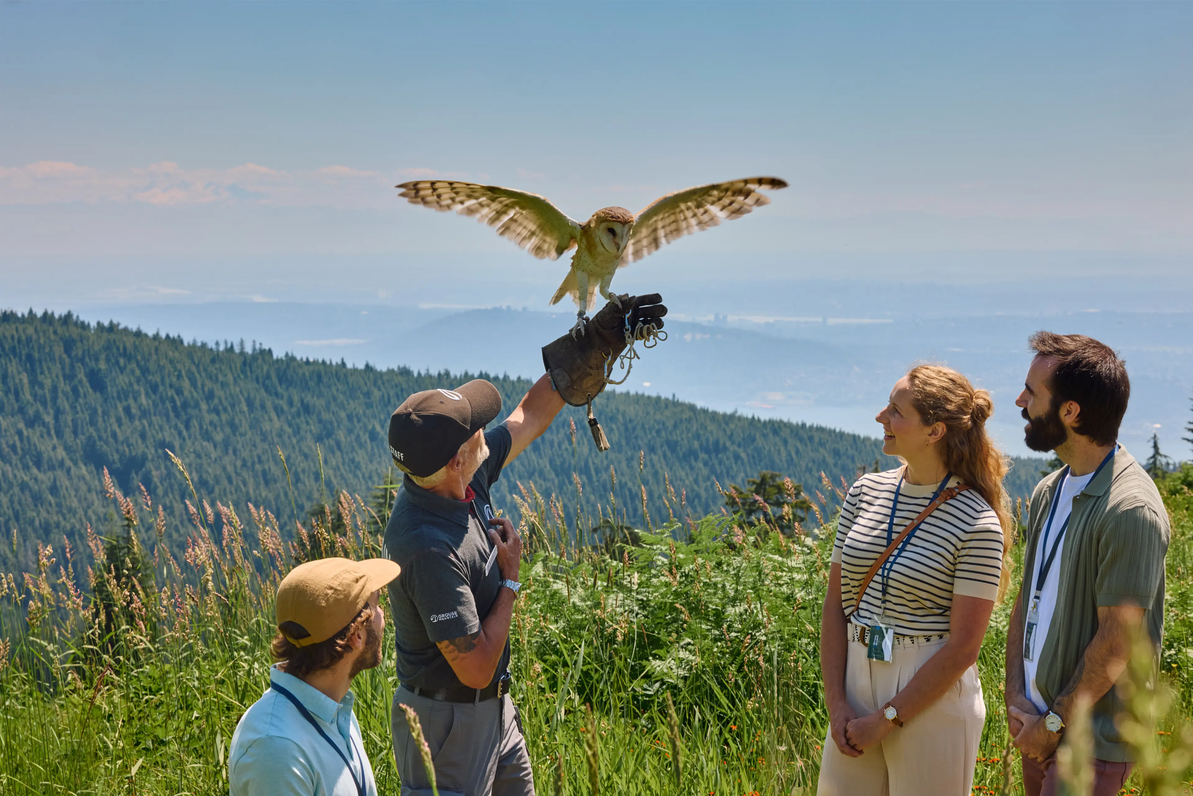 A guide on grouse Mountain holding up an owl on his arm during the Birds in Motion show..