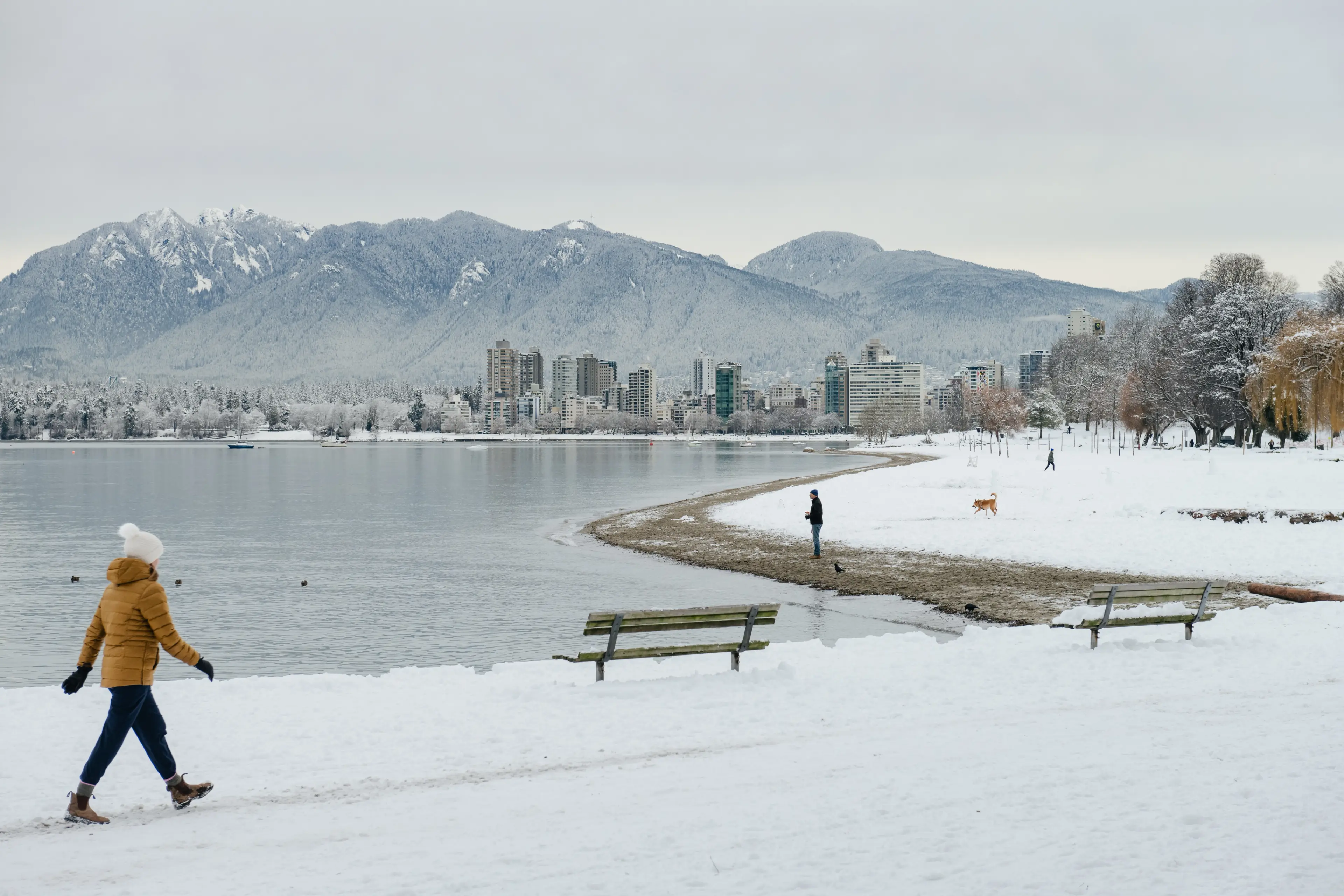 A woman walks through the snow at Kitsilano Beach in Vancouver