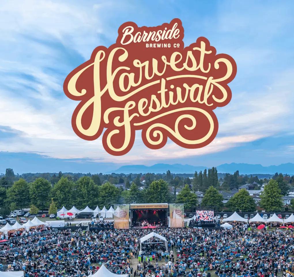 Large outdoor crowd at a festival with tents and a stage under a blue sky with text Barnside Brewing Co Harvest Festival
