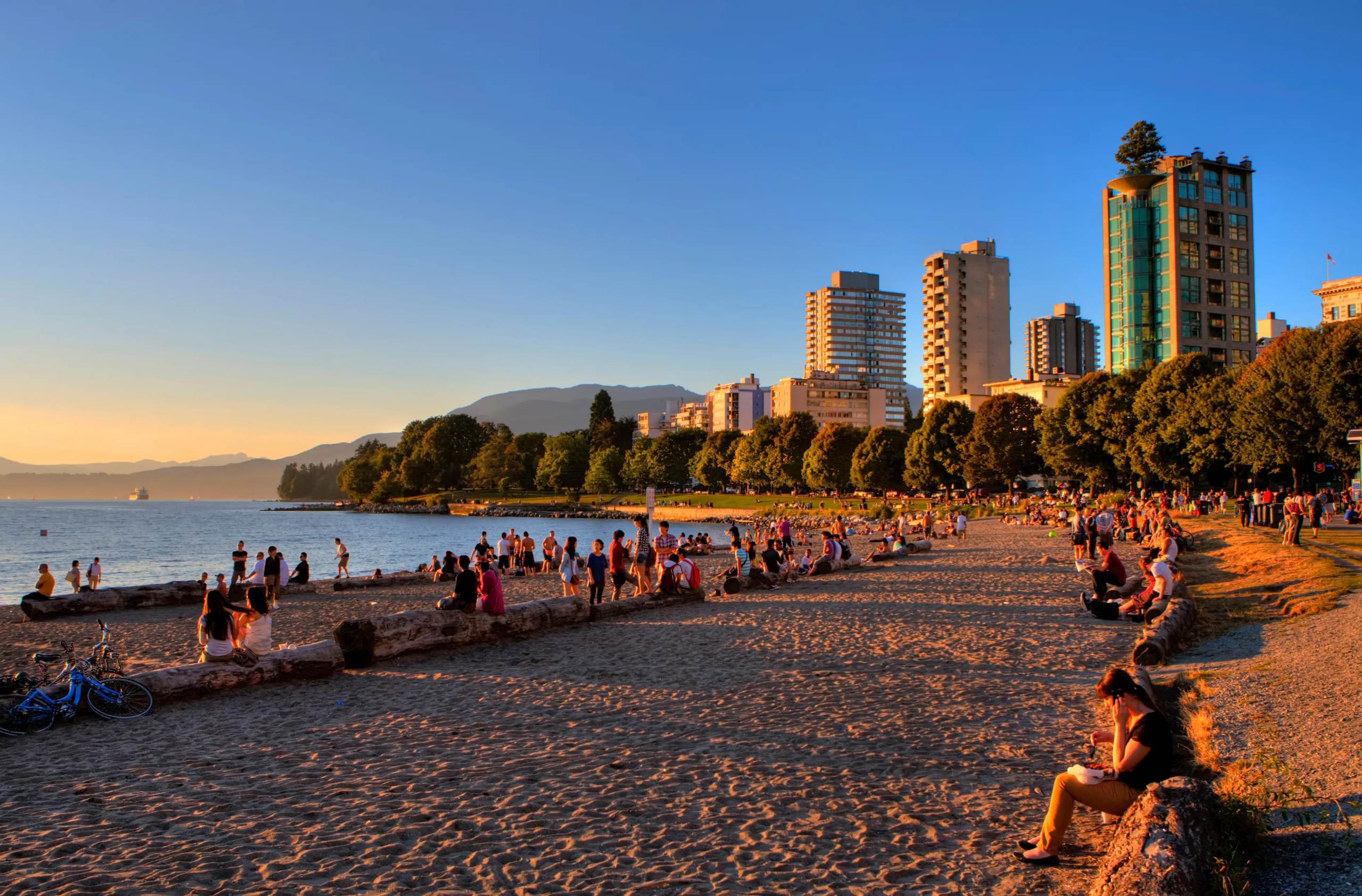 A wide-angle, golden-hour shot of English Bay Beach in Vancouver during a vibrant sunset. 