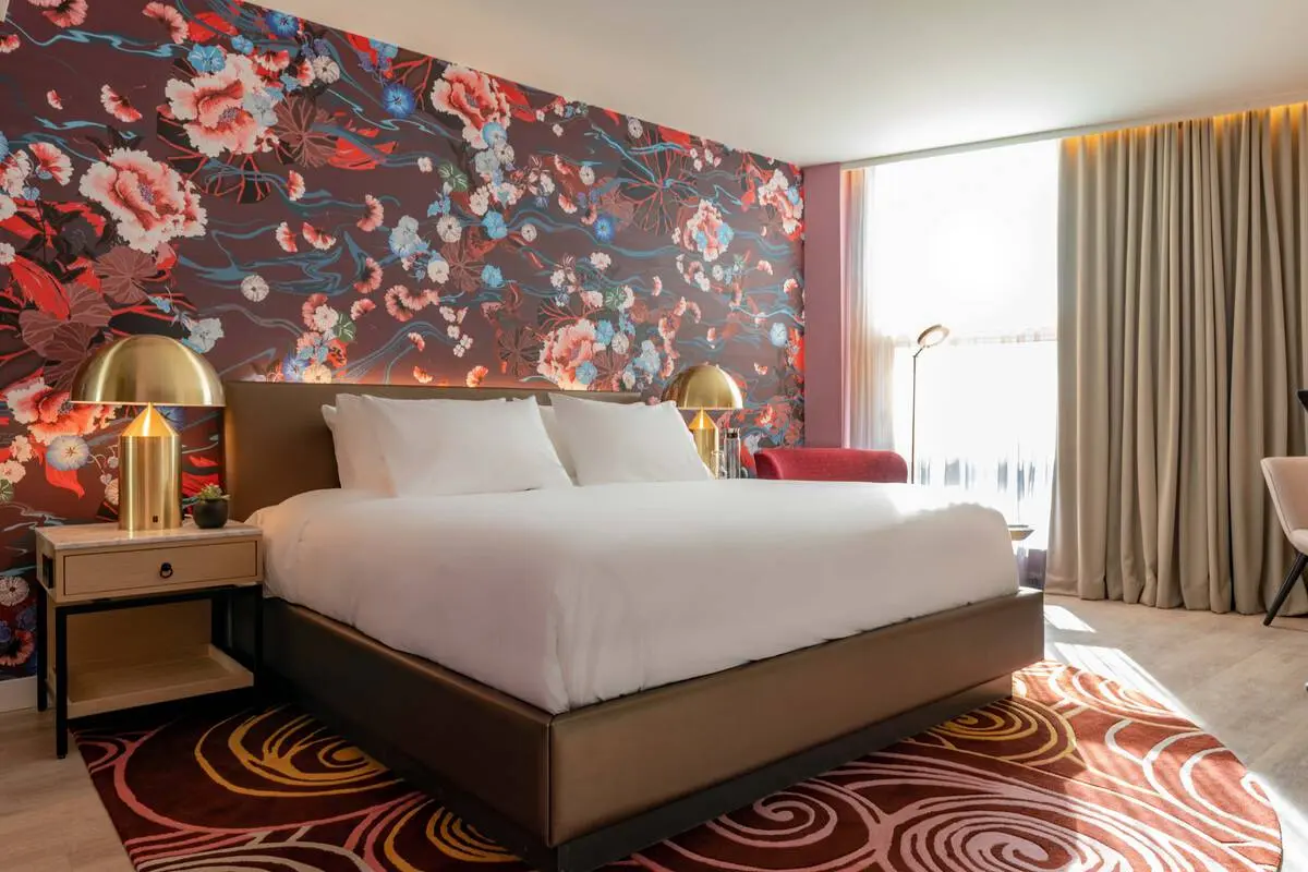 A hotel room at the Versante Hotel in Richmond with brightly coloured rugs and wallpaper.