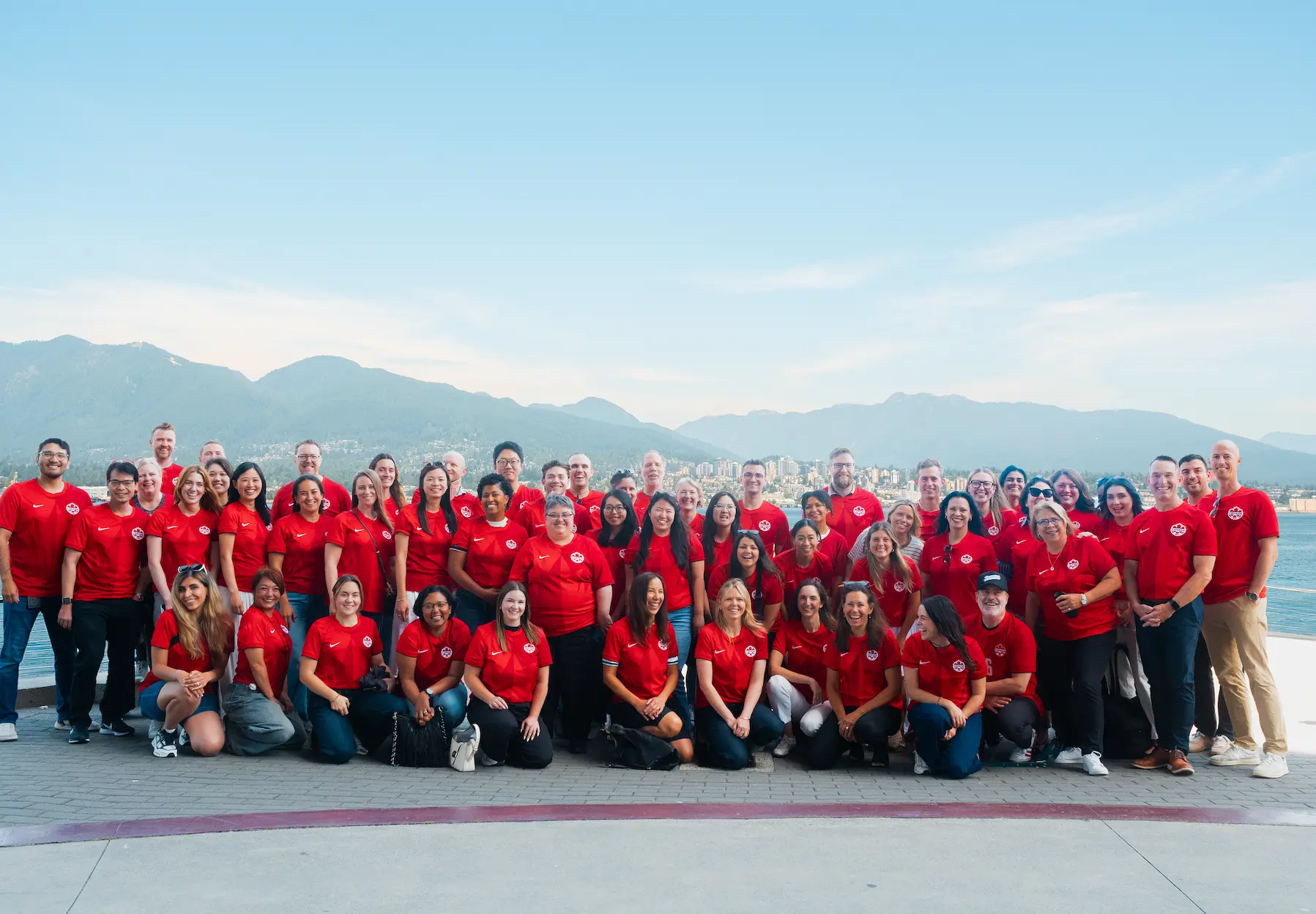 The Destination Vancouver Team posing for a team photo and wearing Canadian football jerseys