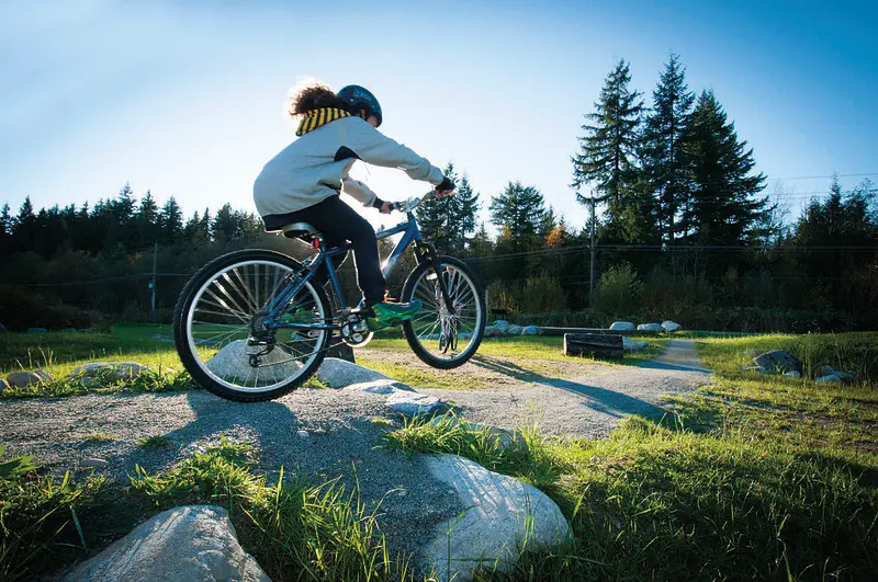 A cyclist hits a small jump at the Mundy Park Bike Skills Park