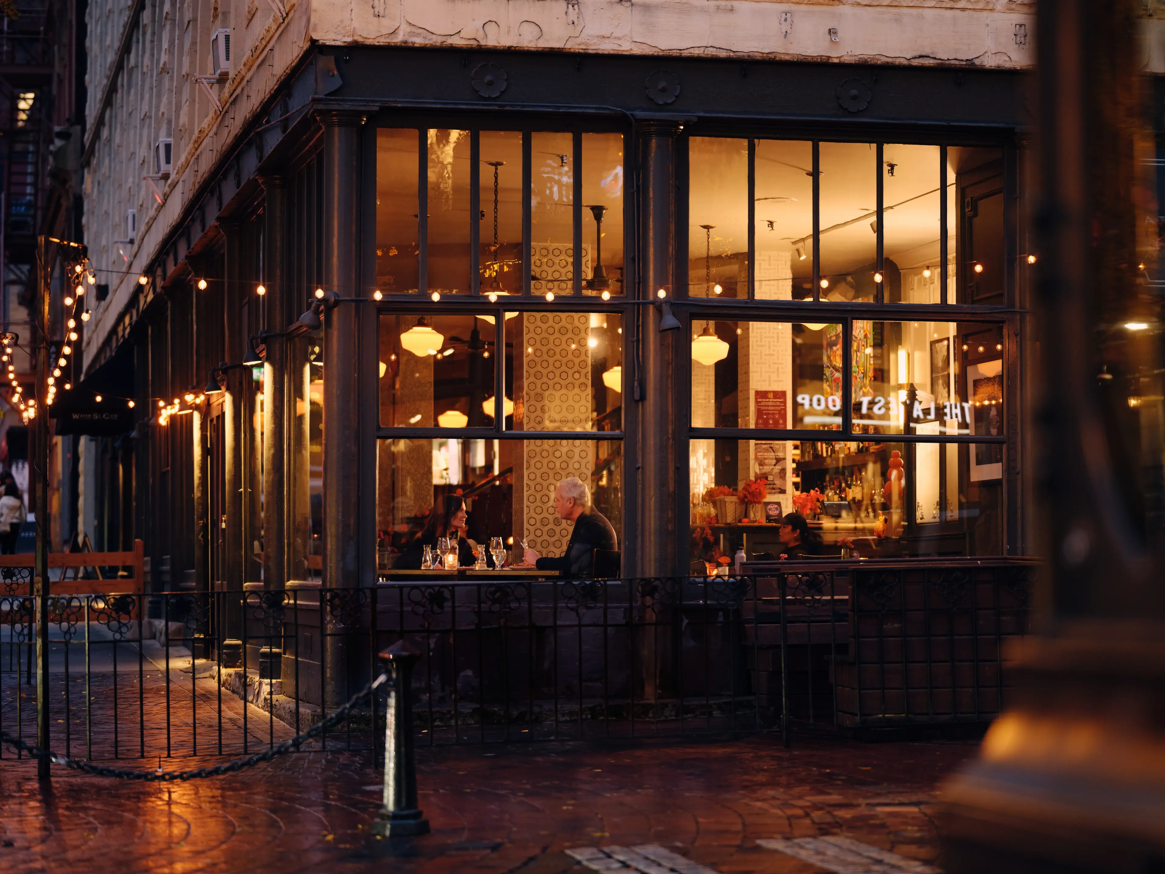 Exterior view looking through the windows of a romantic dinner setting of the Water Street Cafe.