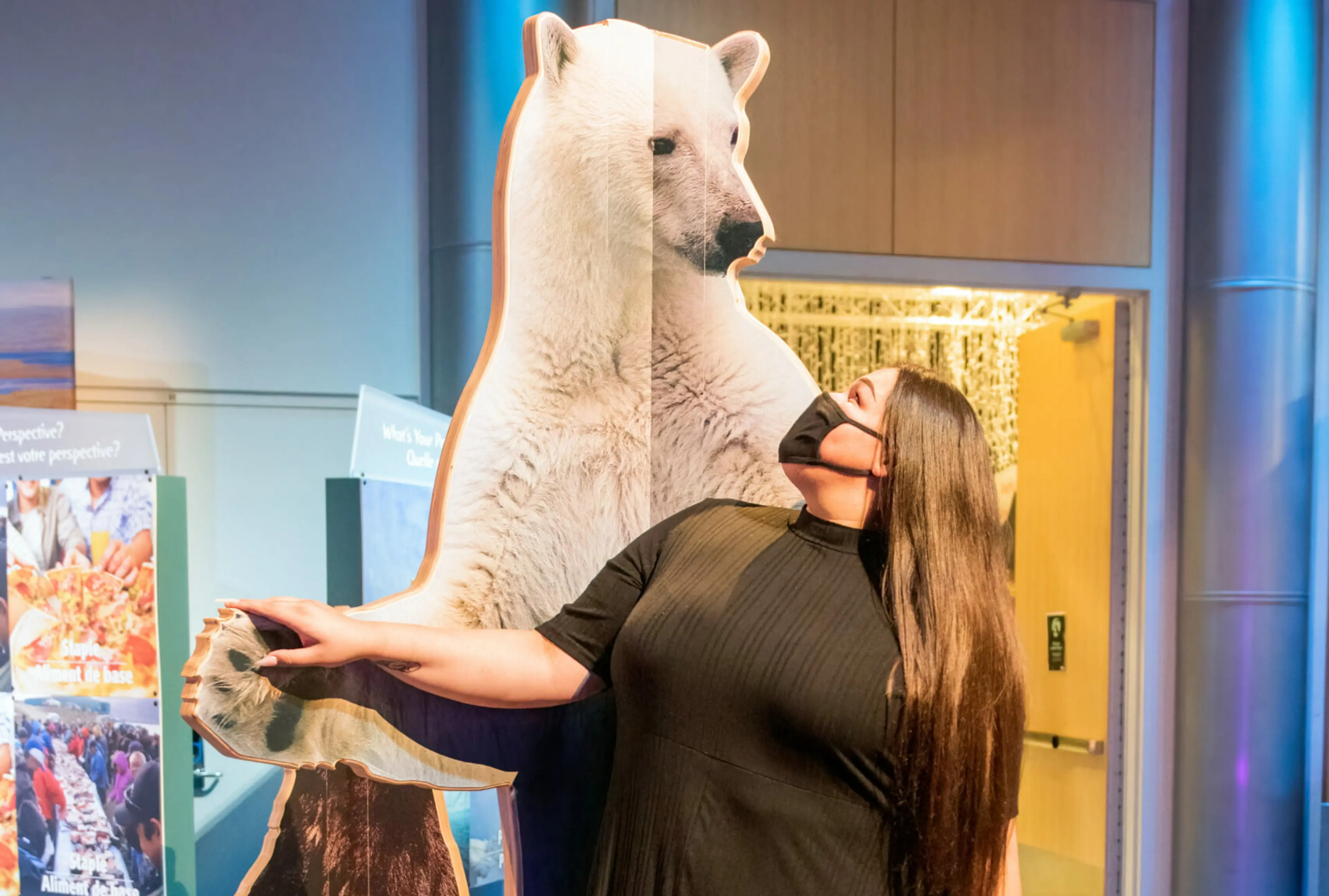Woman standing in front of a polar bear cut out at Science World in Vancouver