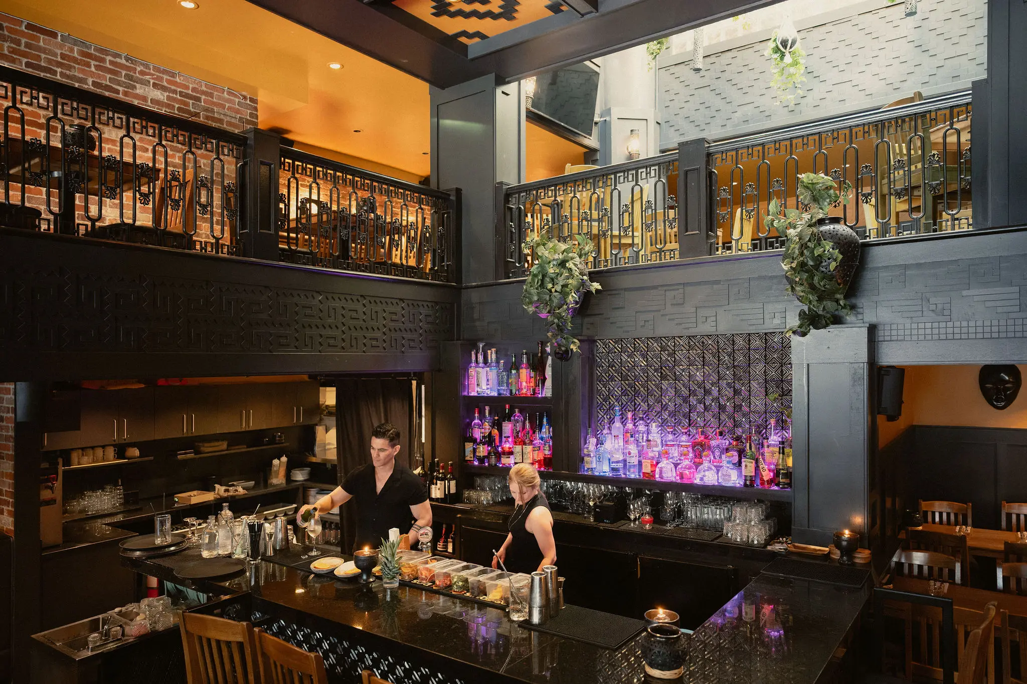 Interior image of the Zapoteca restaurant in Kitsilano with two bar tenders mixing drinks.s