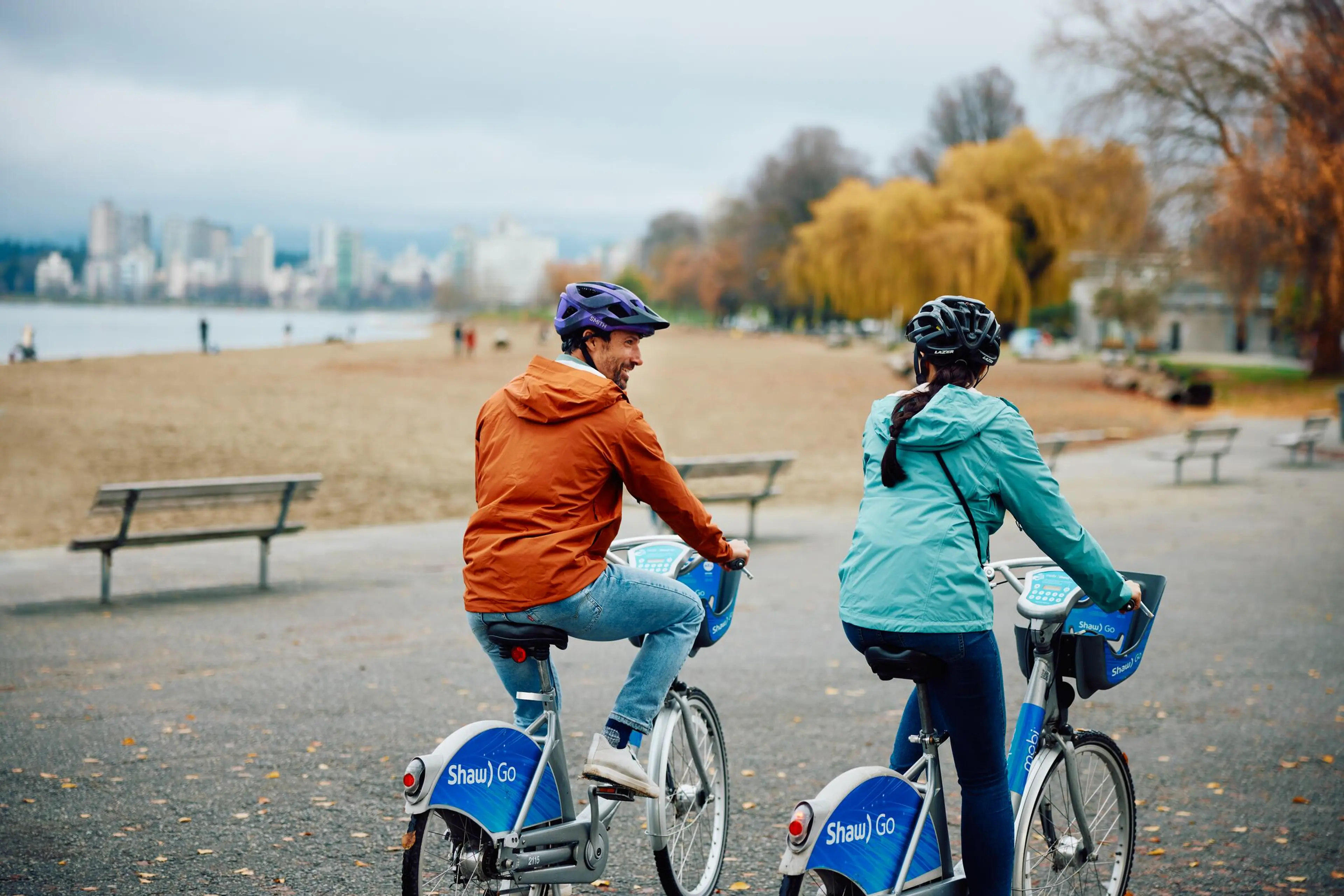 Two people ride Mobi bike share bikes in Vancouver.