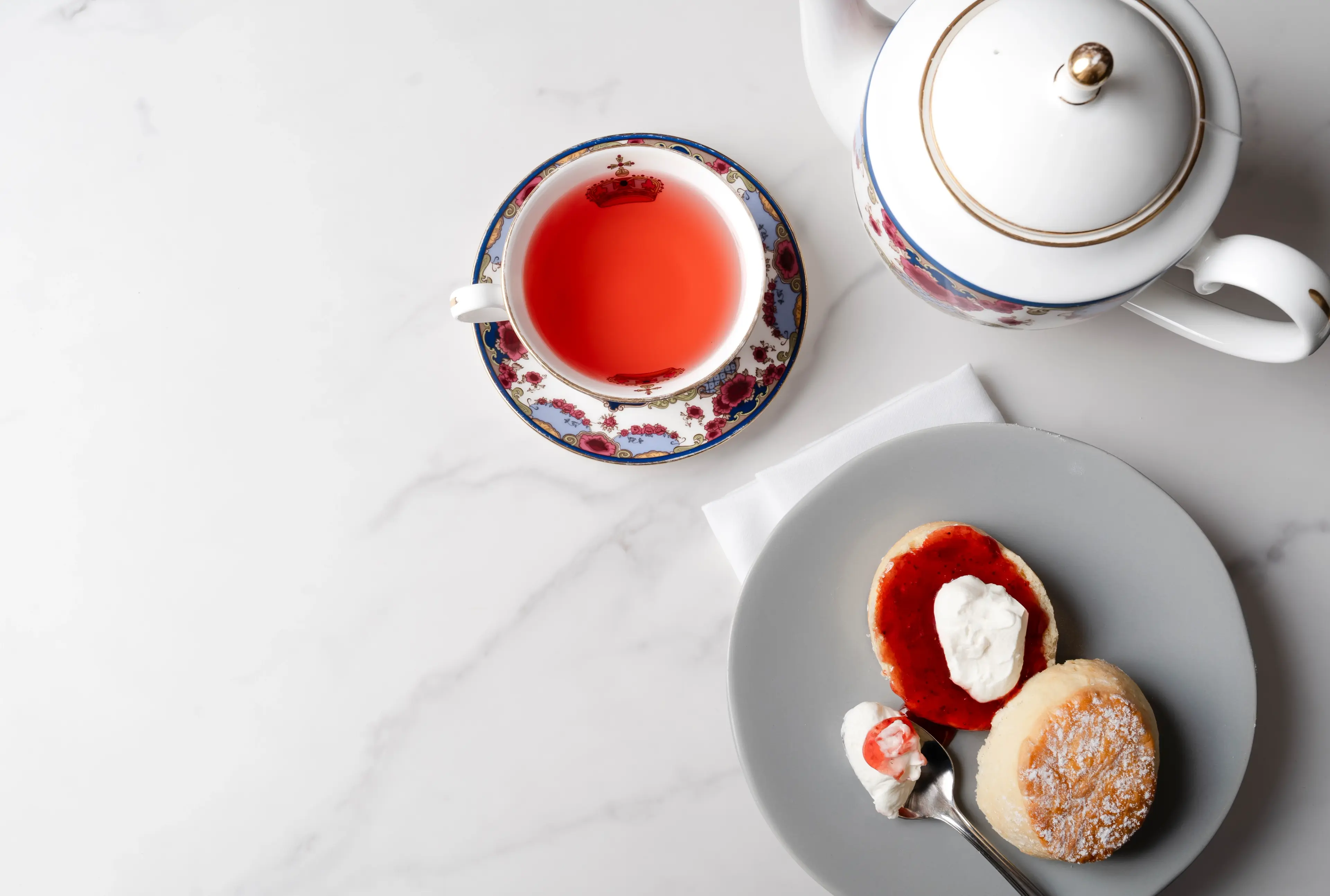 An overhead shot of a teapot, teacup and plate of sweets at afternoon tea at Notch 8. 