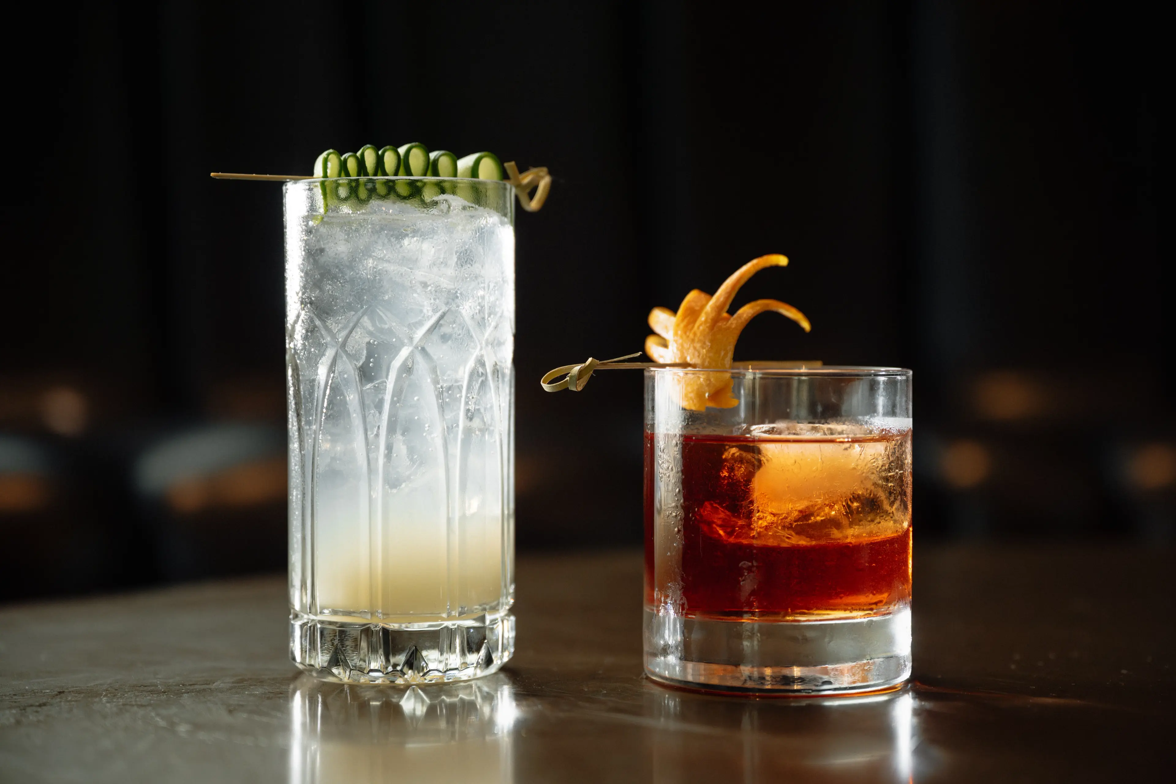 Image of two cocktails with beautiful garnishes.