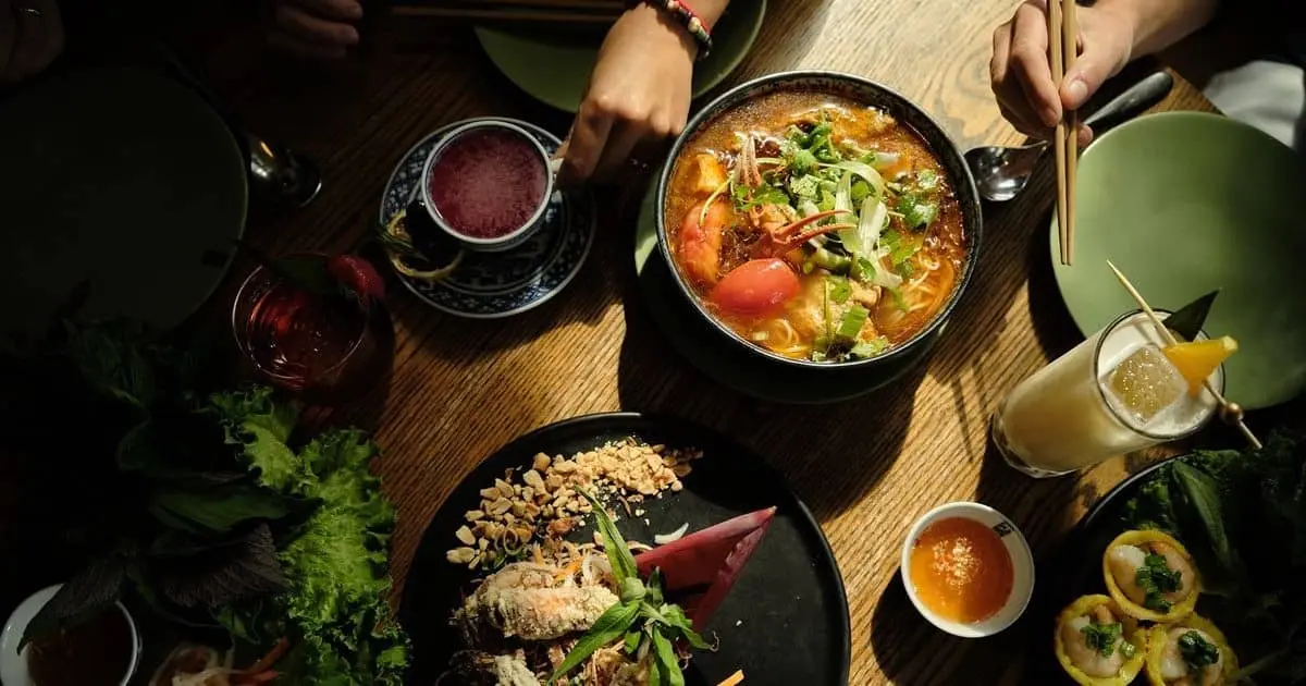 Vietnamese Pho and other dishes are laid out on a table ready to eat.