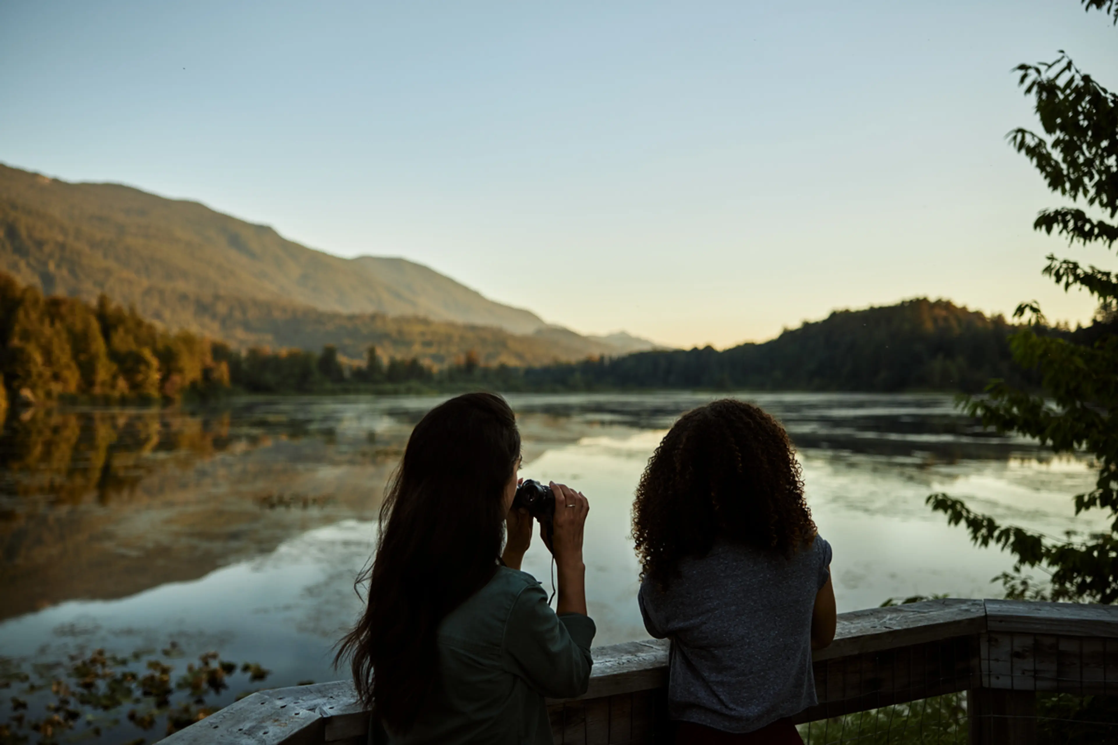 Two women watching birds through binoculars near Vancouver