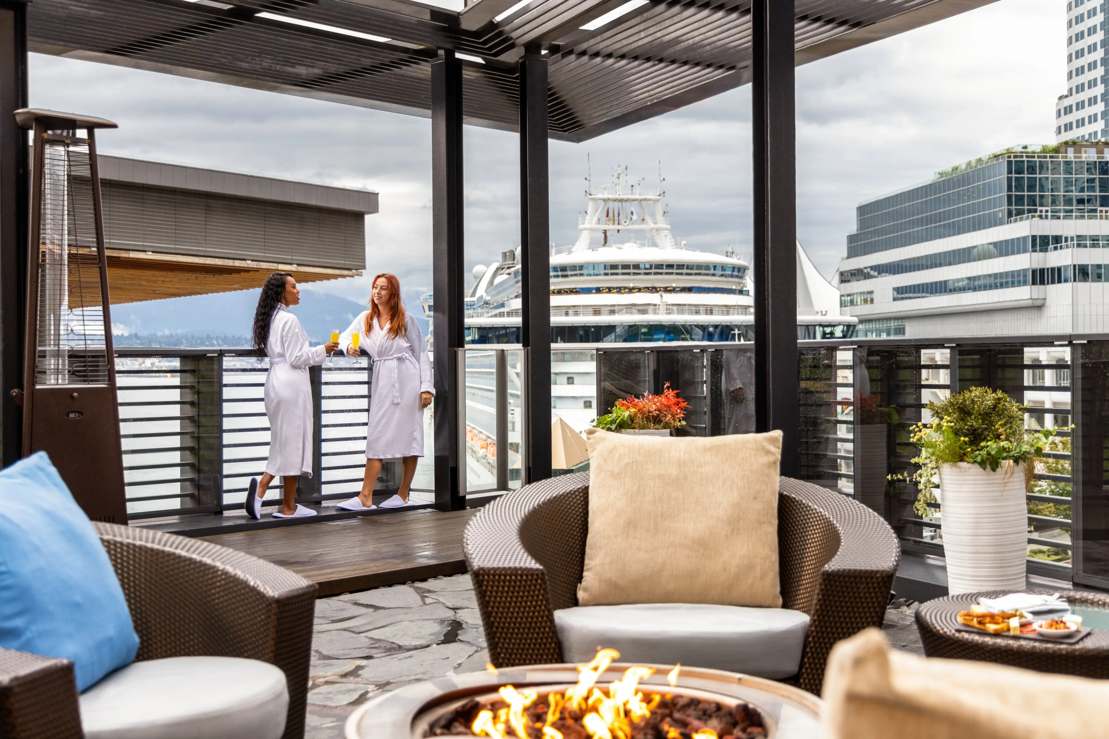 Two women in robes enjoy the outdoor area at the Fairmont Pacific Rim Spa.