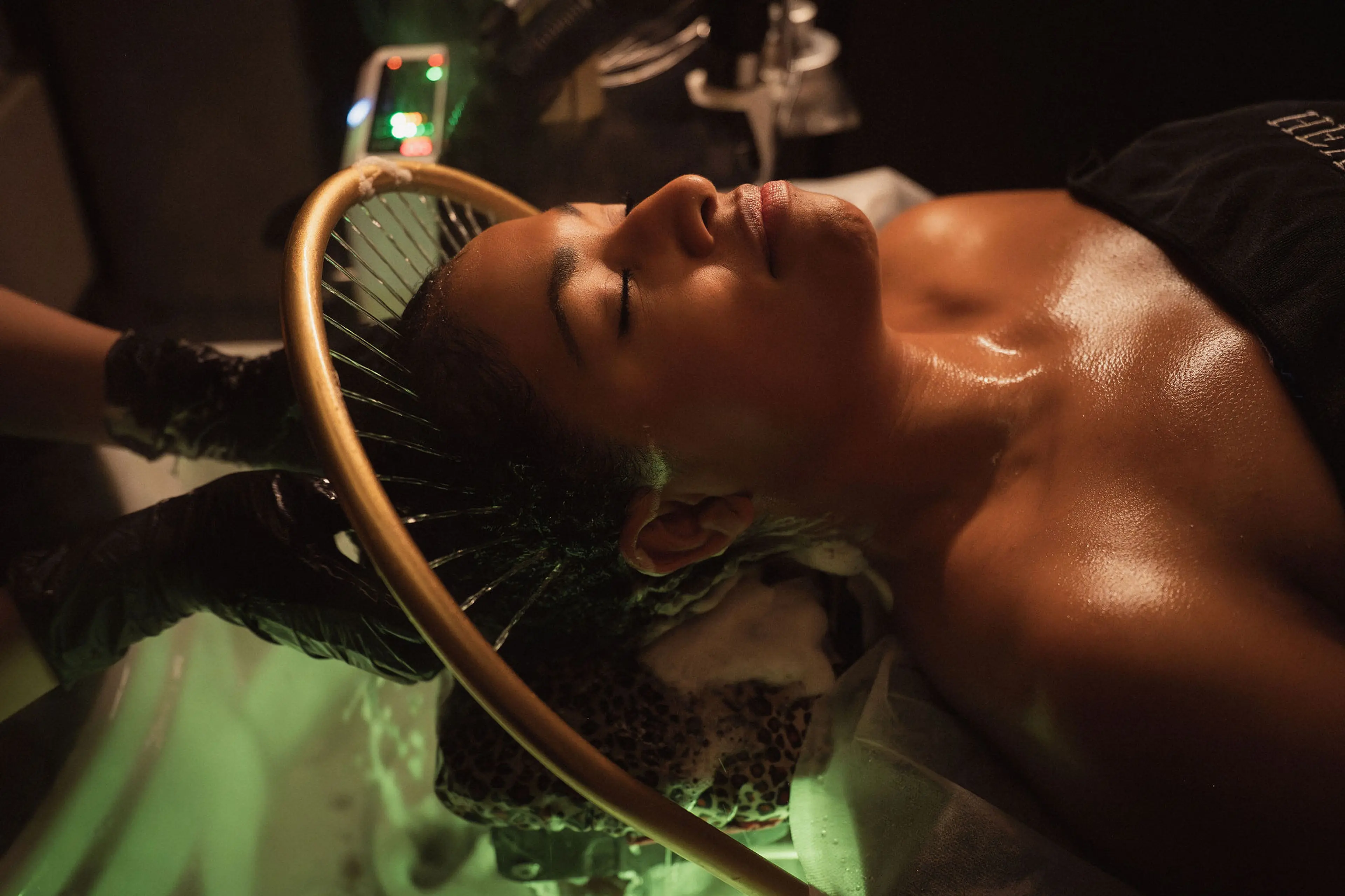 A person under a head spa water halo at Headicure Head Spa in Vancouver.