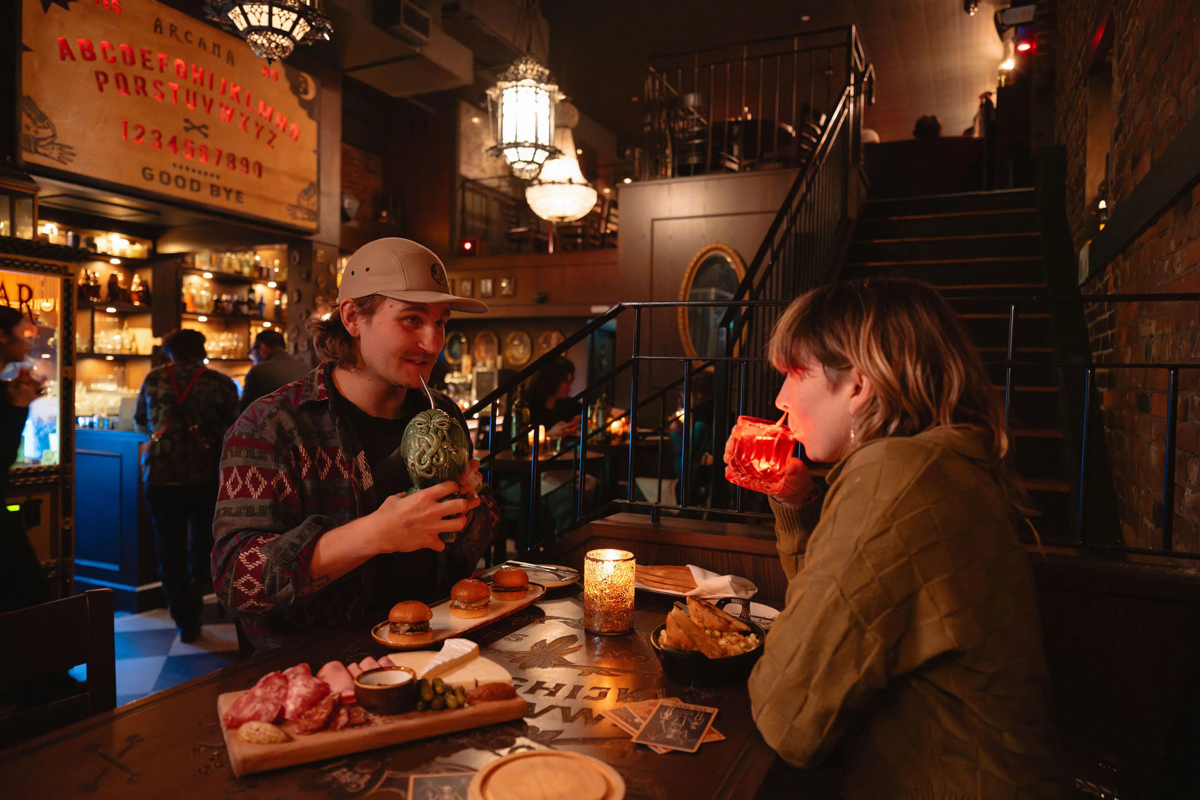 A couple dining and having drinks at Arcana Food and Spirits in Vancouver.
