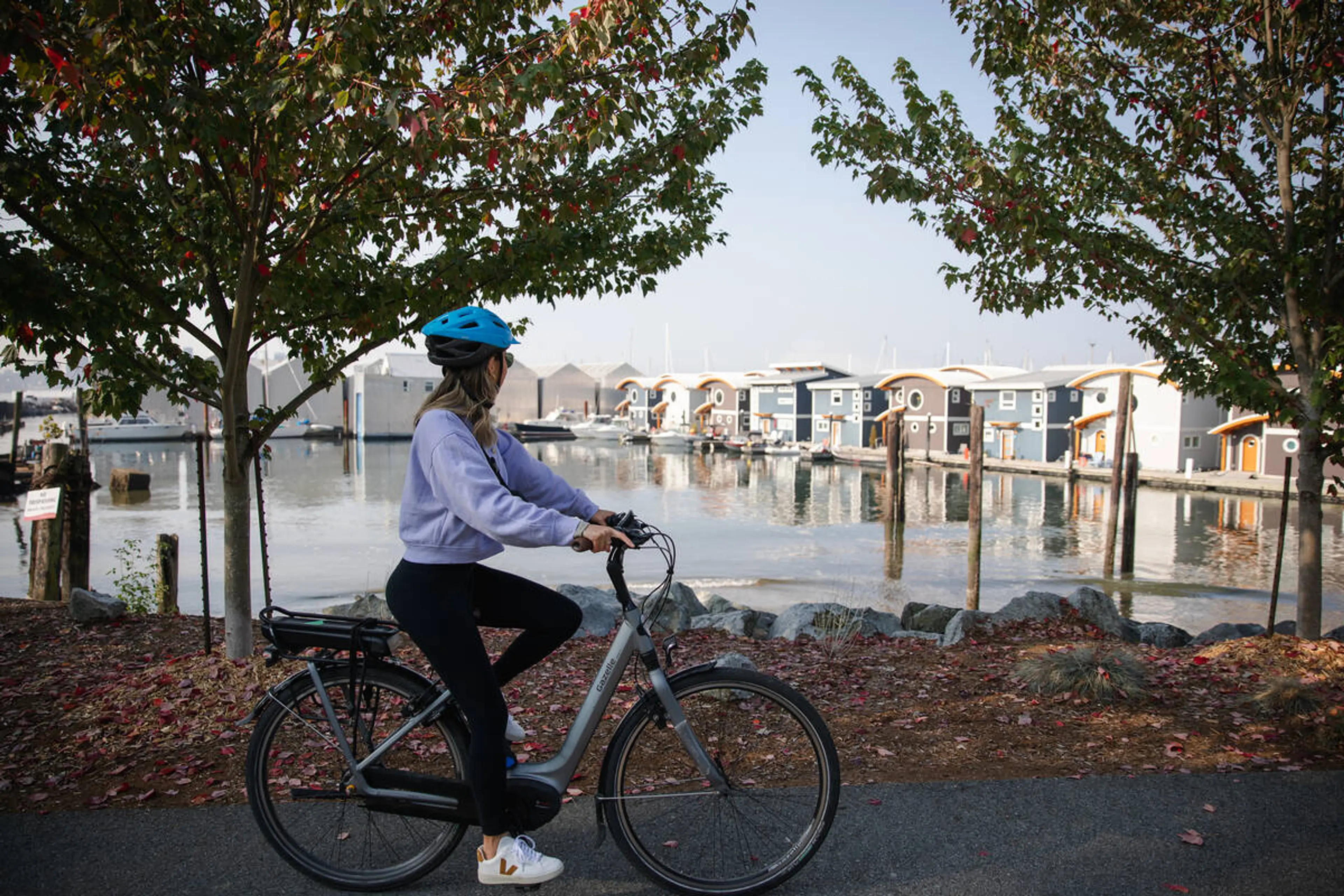 A woman wearing a bike helmet bikes along the Spirit Trail in North Vancouver