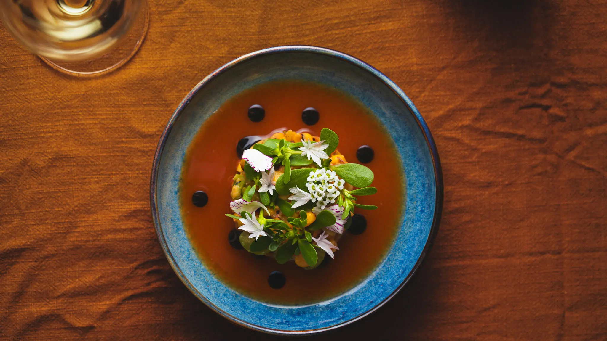 A beautifully plated dish at Burdock & Co. in Vancouver, topped with delicate edible flowers and artistic garnish.