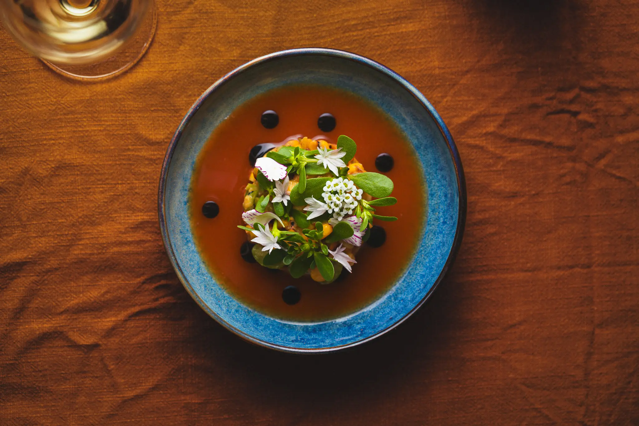 A beautifully plated dish at Burdock & Co. in Vancouver, topped with delicate edible flowers and artistic garnish.