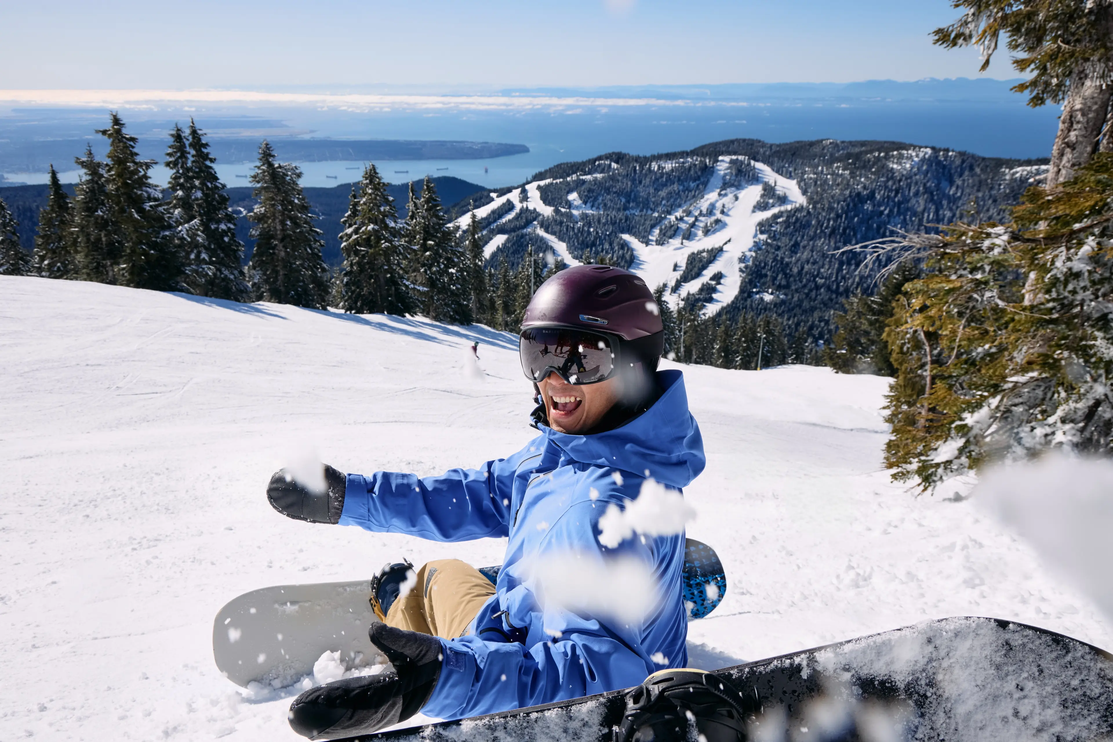 A snow boarder throwing snow and having fun on Cypress Mountain in West Vancouver.
