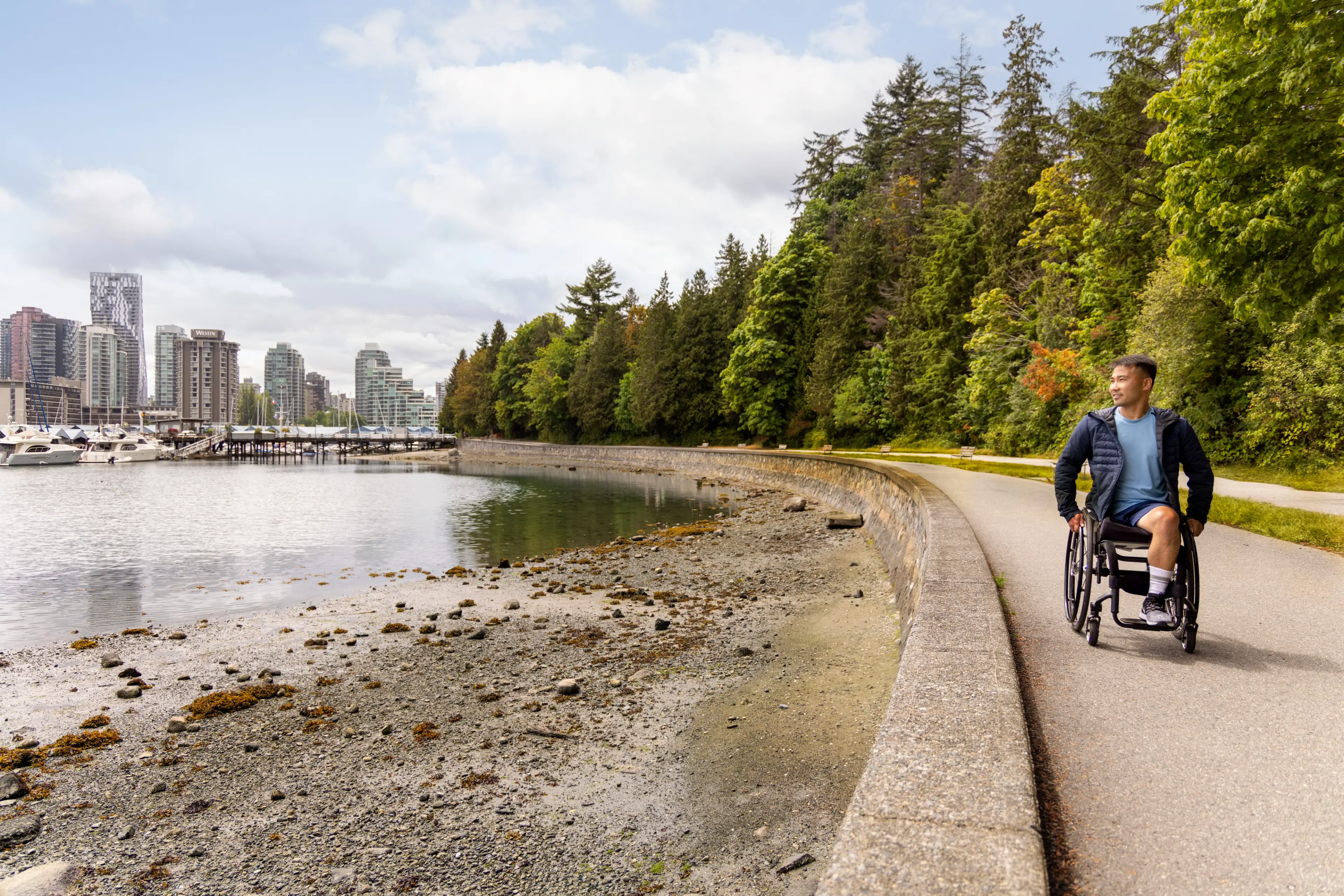 Wheelchair user along the Seawall in Stanley Park looking out