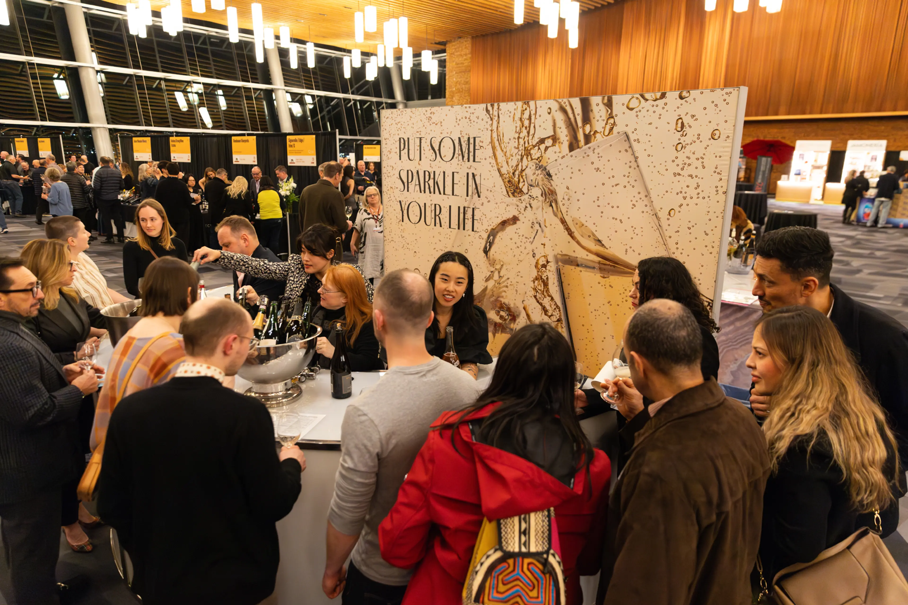 People standing at a wine vendor stand for wine tastings at the Vancouver International Wine Festival.