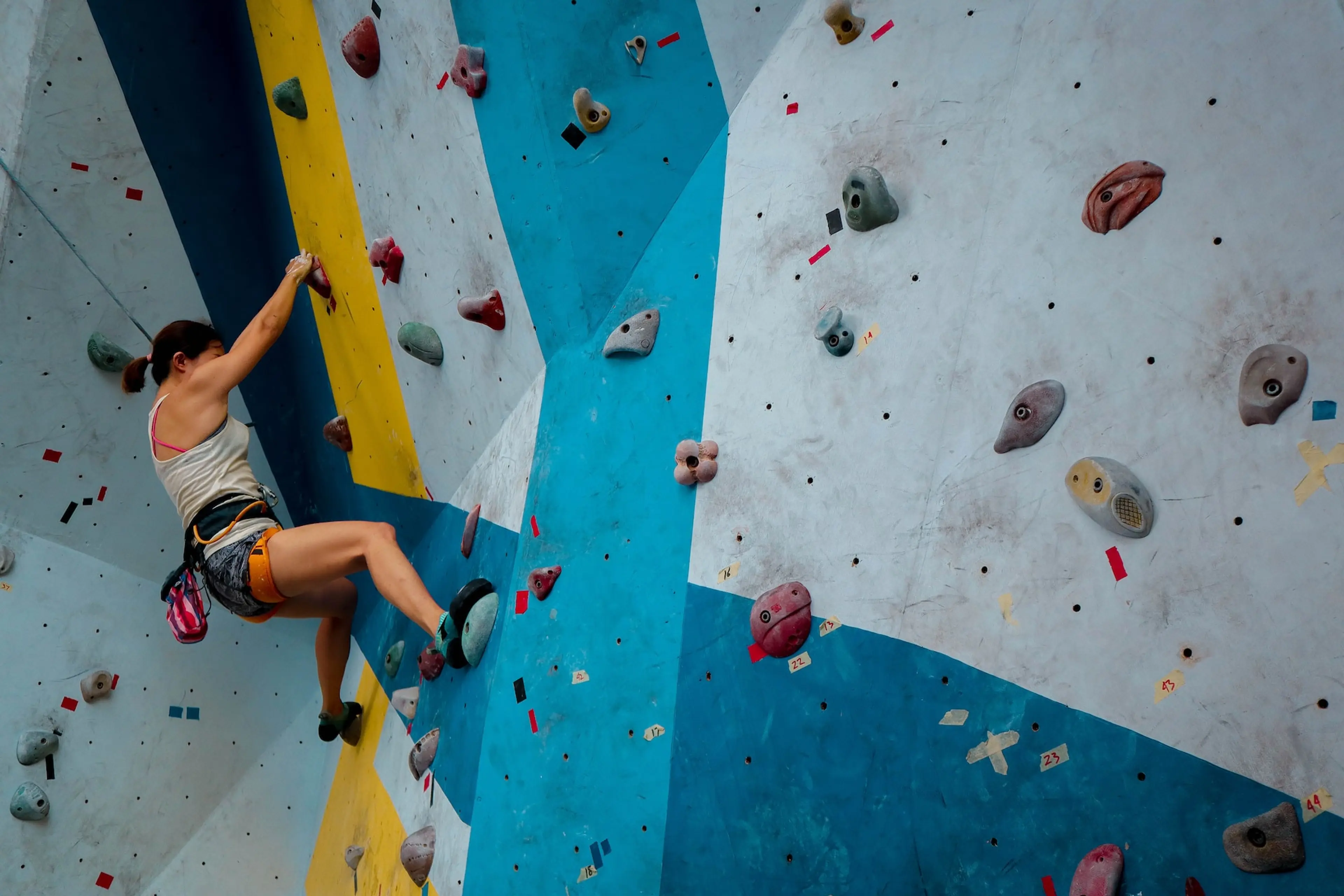 A woman indoor rock climbing. 