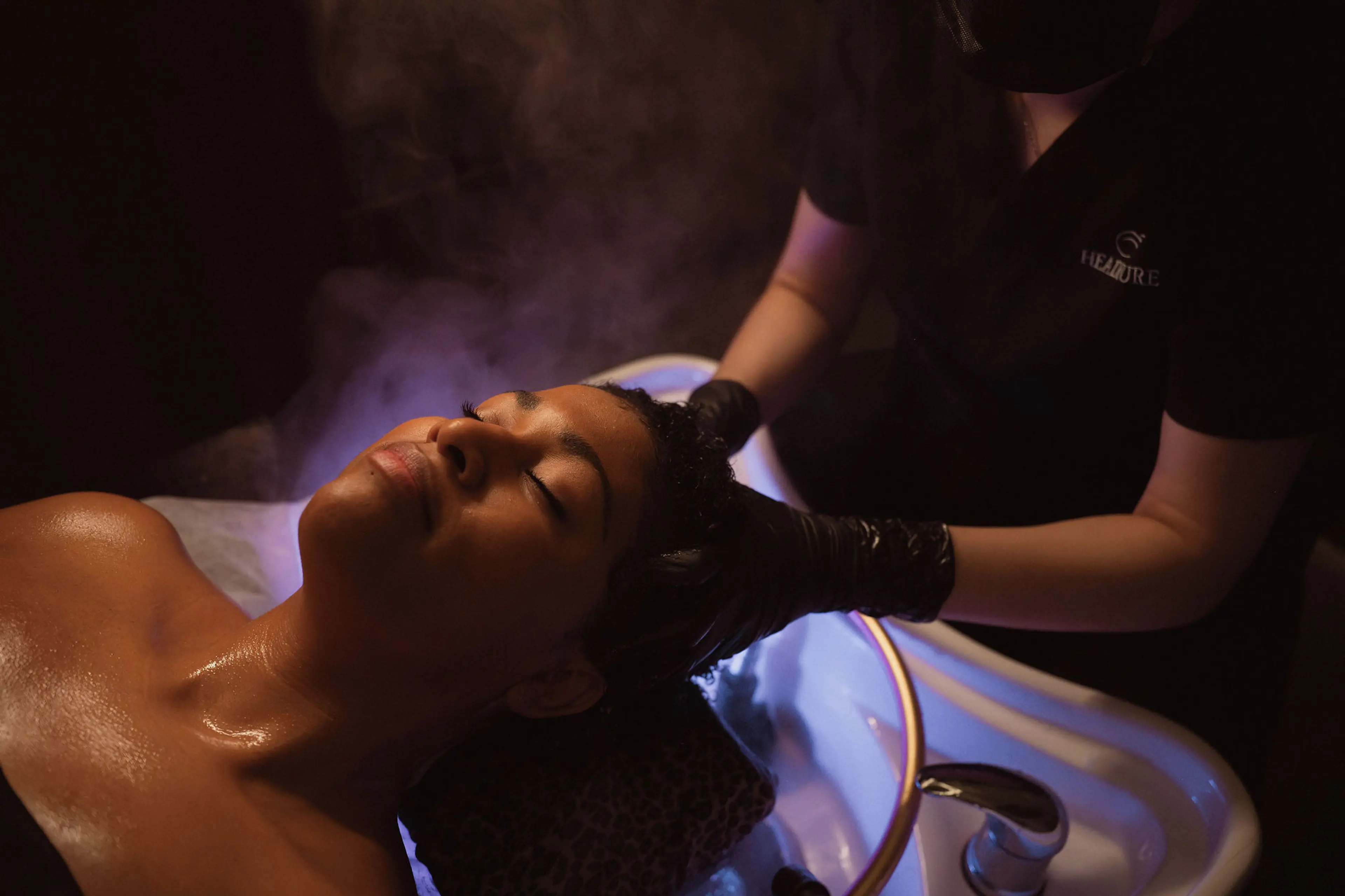 A person getting a sculp massage over the water halo at Headicure in Vancouver.