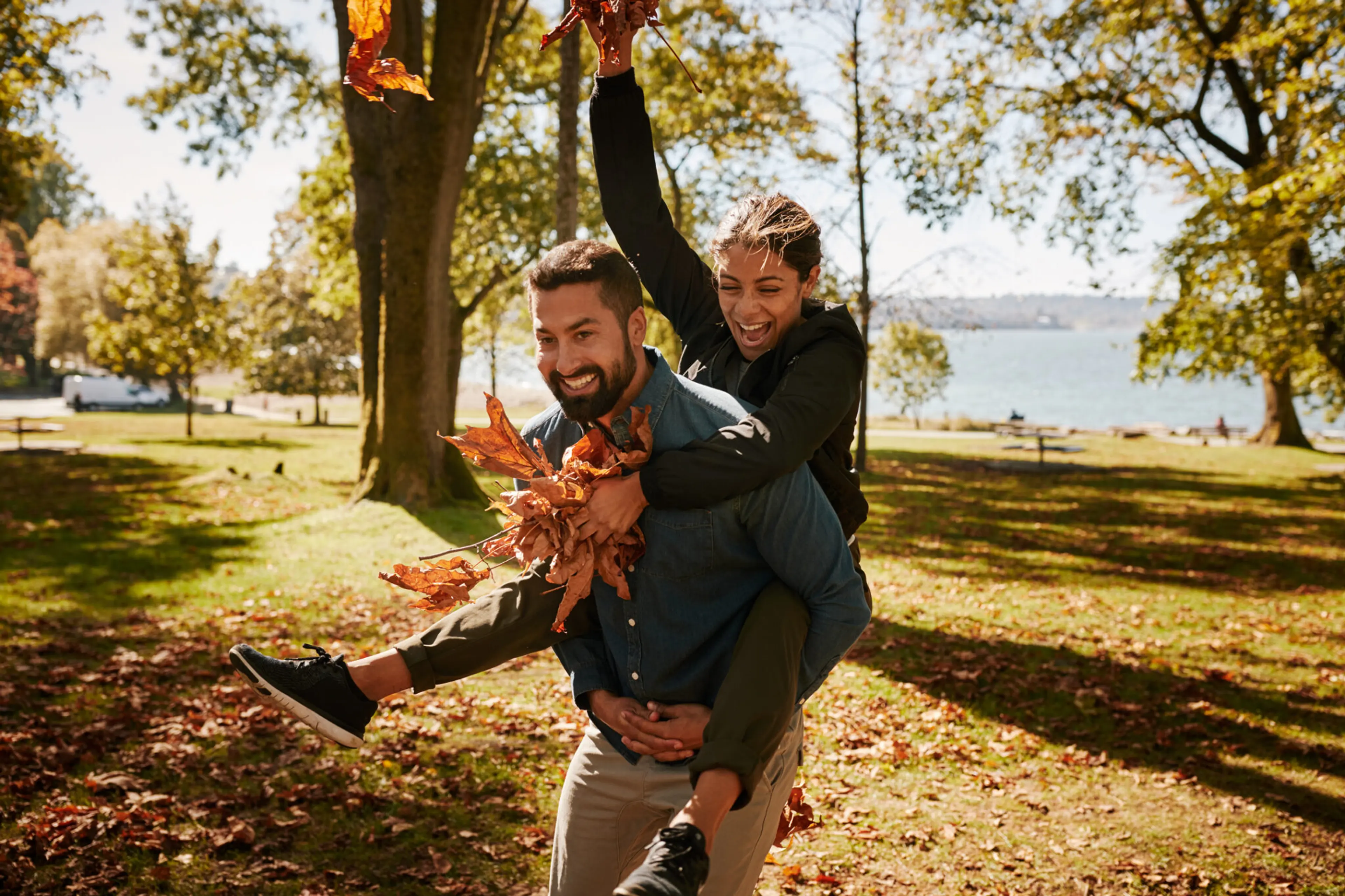 A couple enjoys fallen leaves at a Vancouver Park