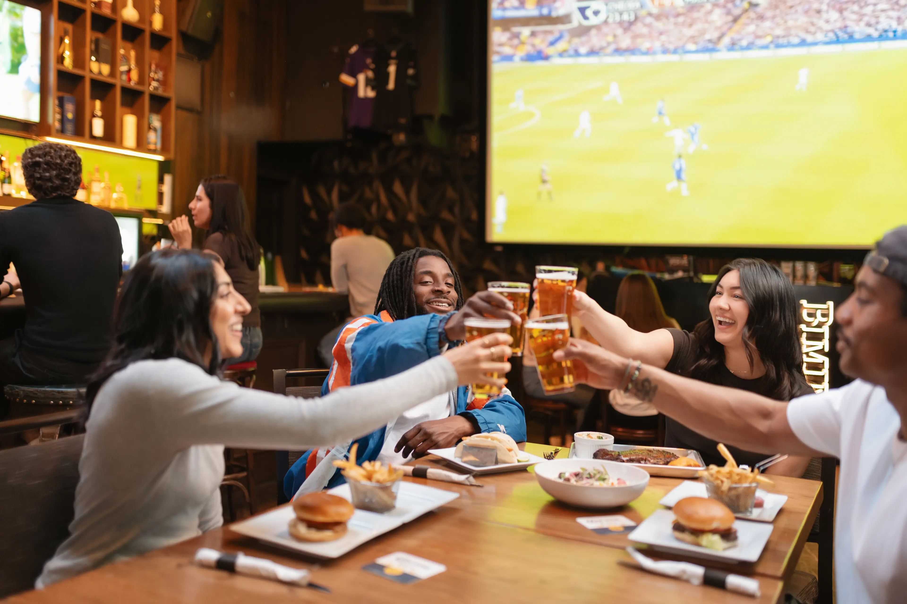 People cheersing with beer glasses at the Bimini's bar in Vancouver.