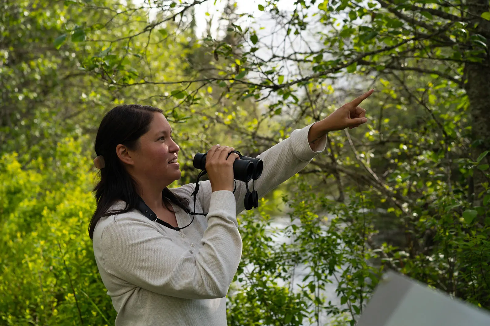 A woman birdwatching at Green Lake in Whistler