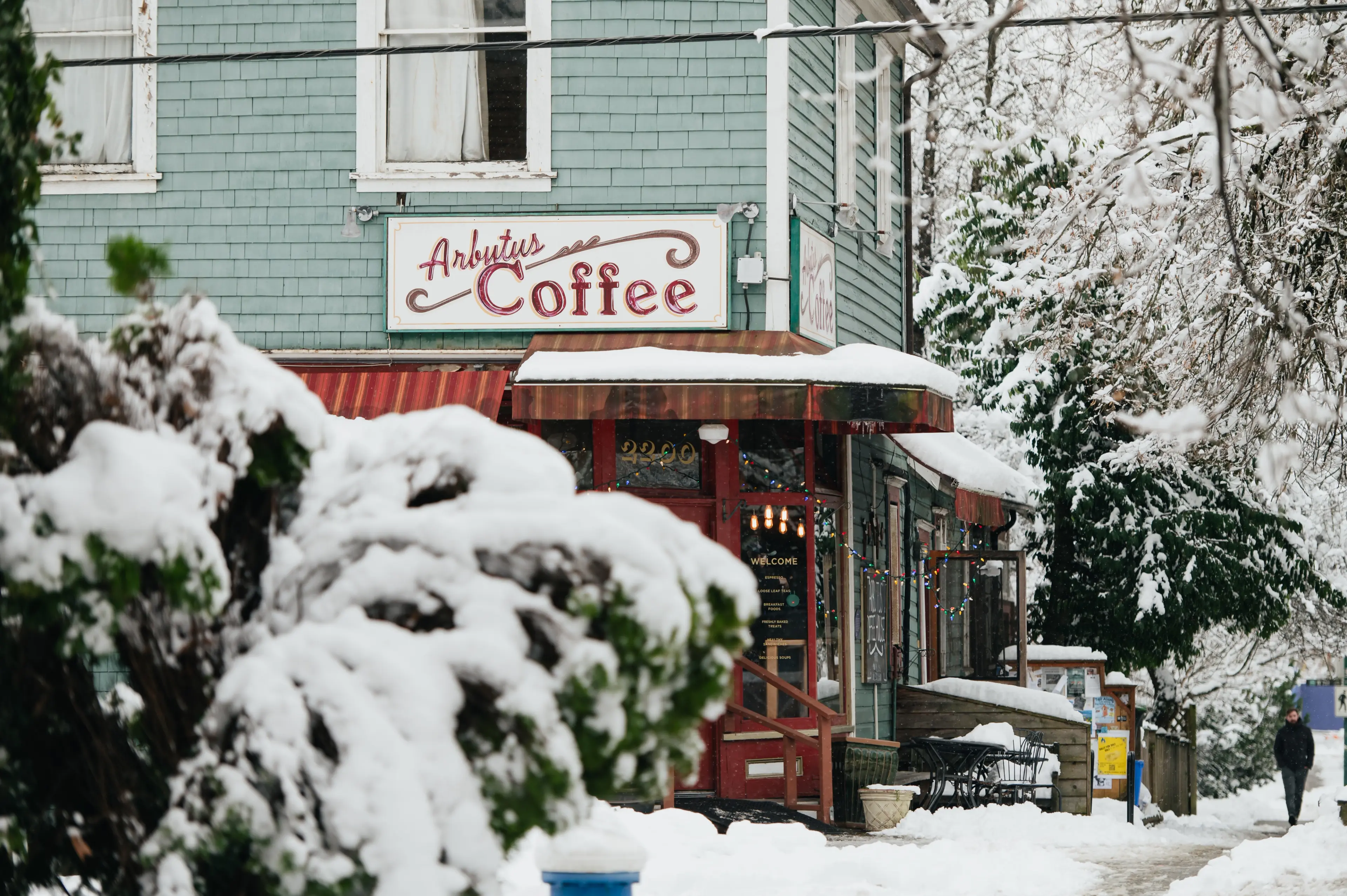 Exterior photo of the Arbutus cafe on a snowy day in Vancouver.