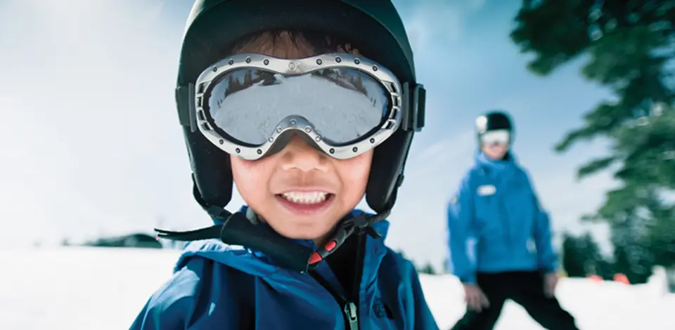 A close-up of a child enjoying a ski lesson at Grouse Mountain in Vancouver