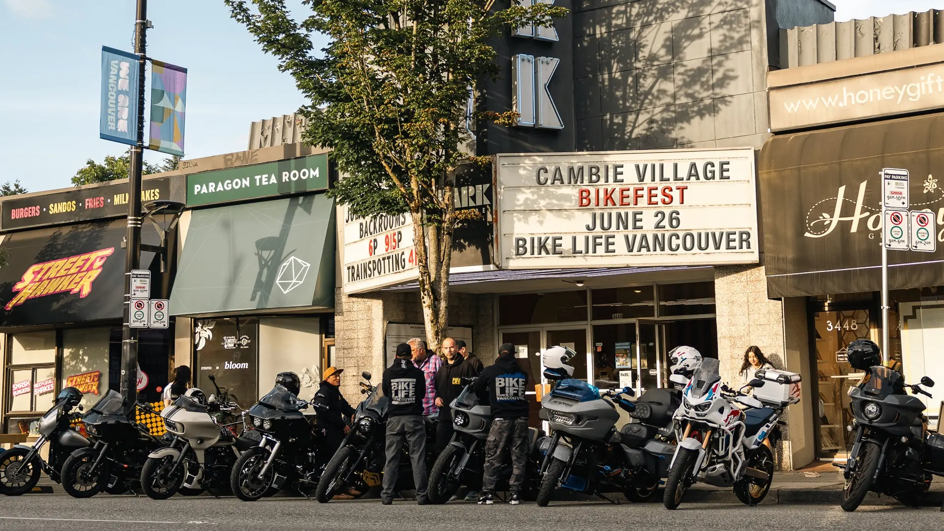Group of people with motorcycles gathered outside Cambie Village Bikefest event venue in Vancouver.