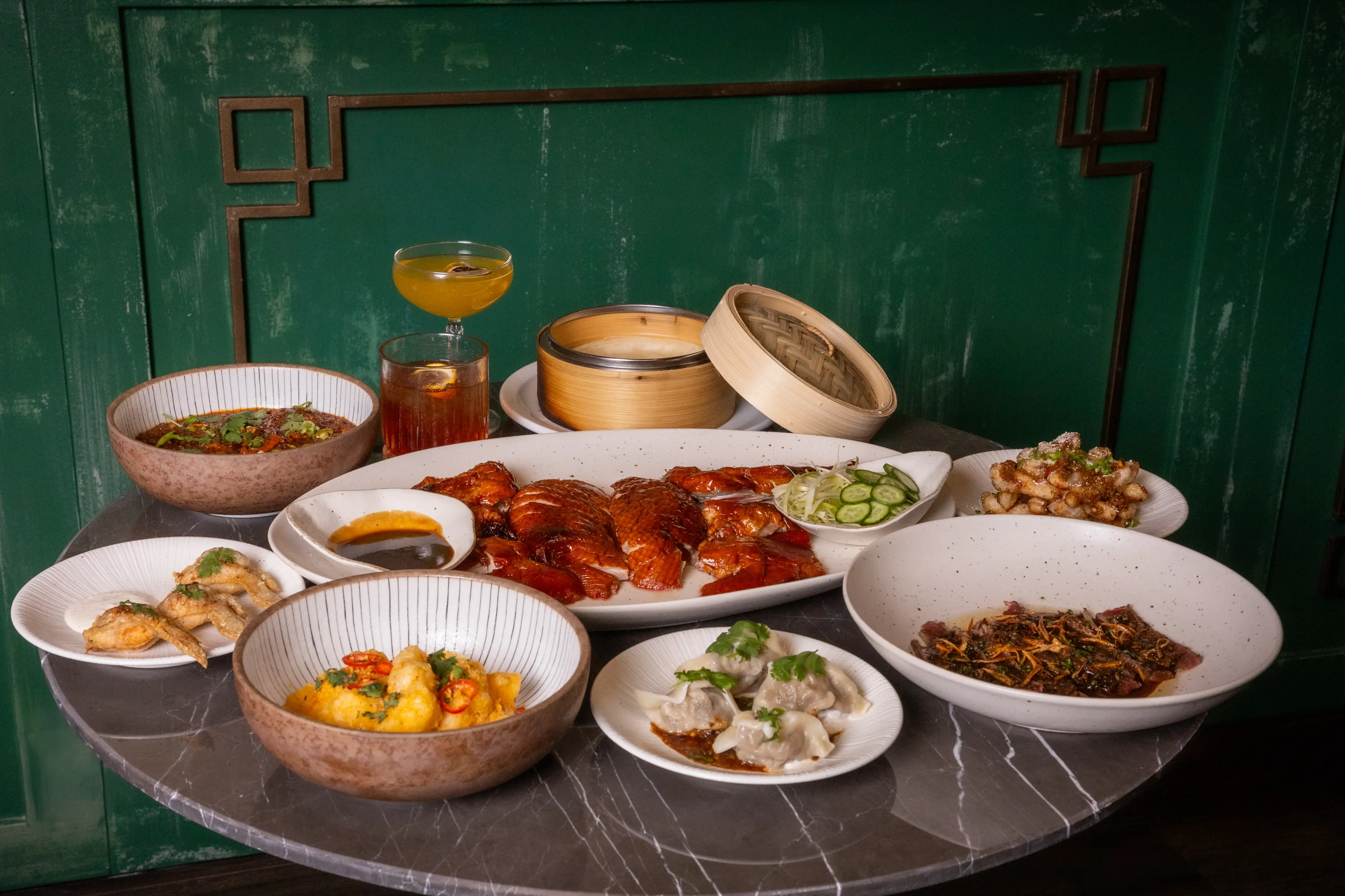 Shot of dishes, including dumplings and roasted duck at Heritage Asian Eatery