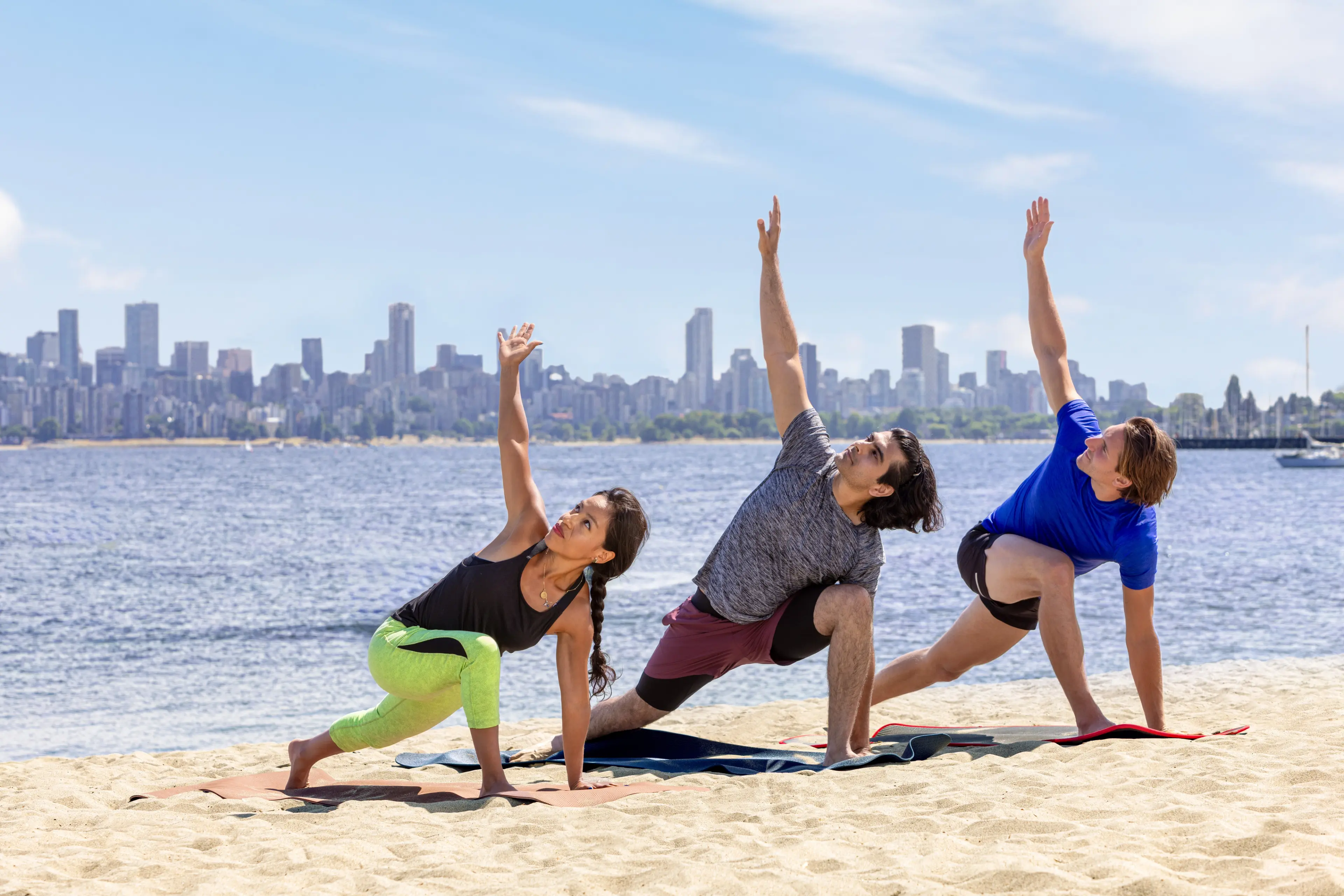 Three people doing yoga on Jericho Beach