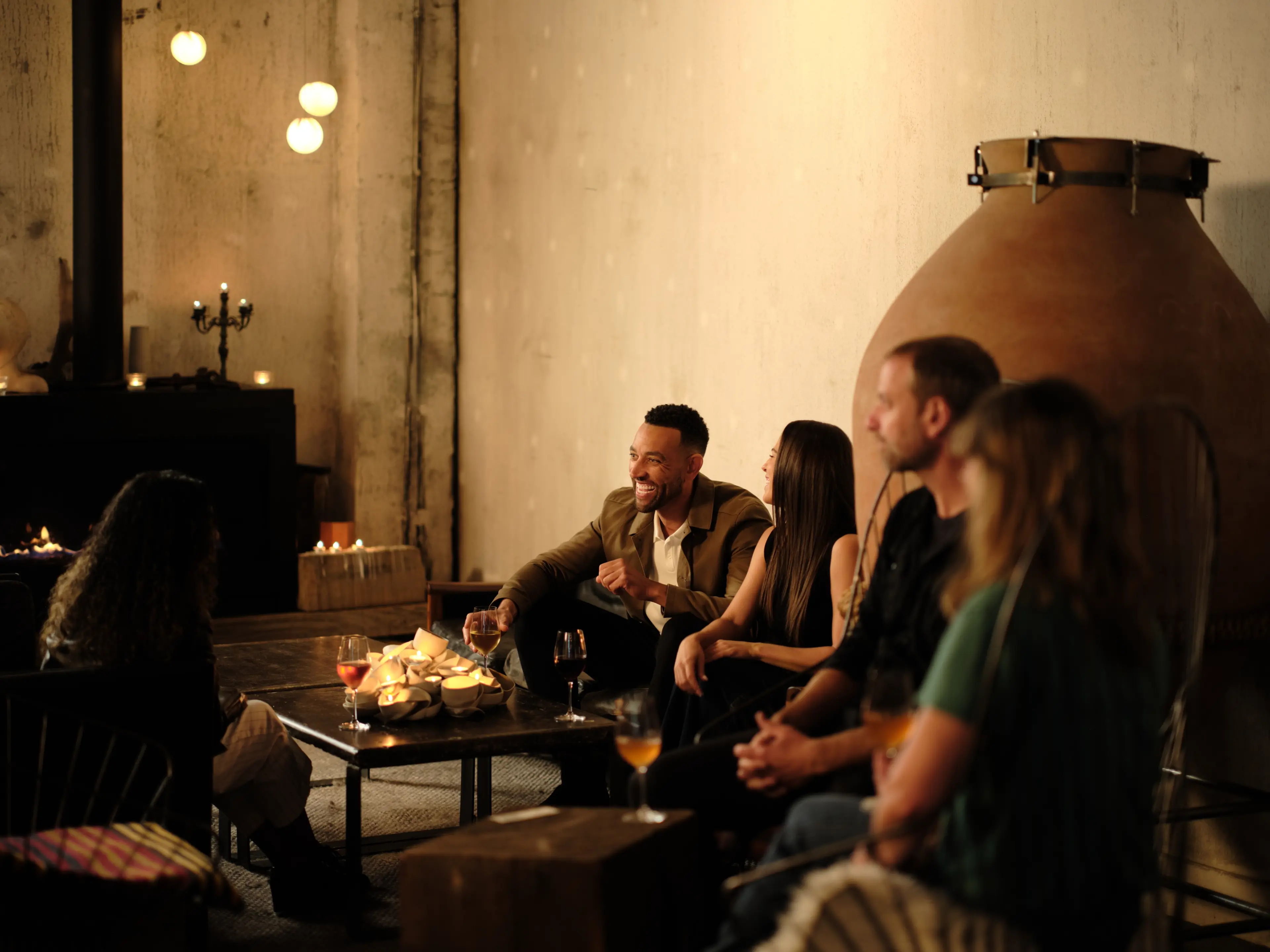 Friends chatting and drinking wine at the La Fabrique St. George winery in Vancouver.