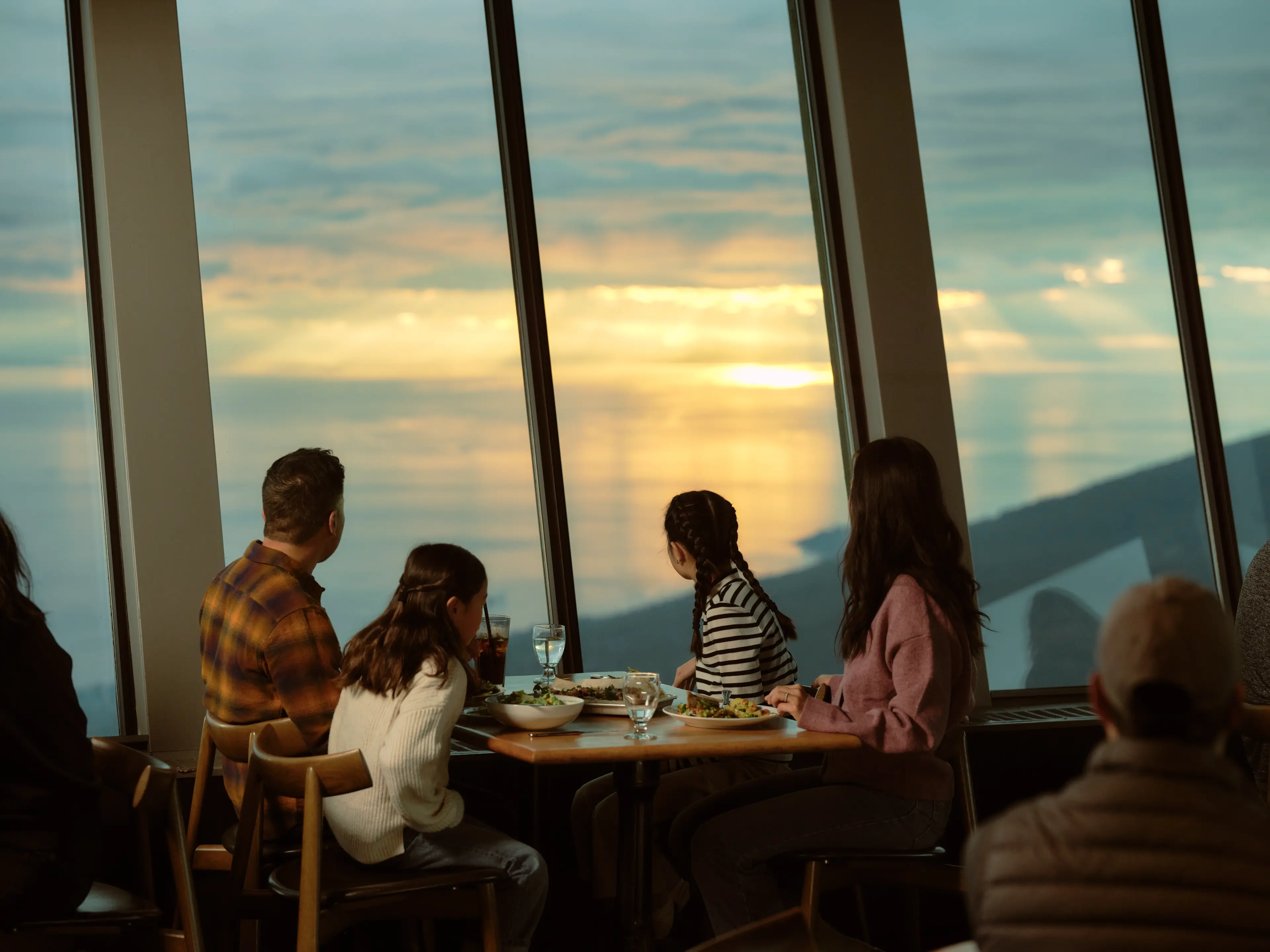 A family enjoys dinner at Grouse Mountain at sunset. 