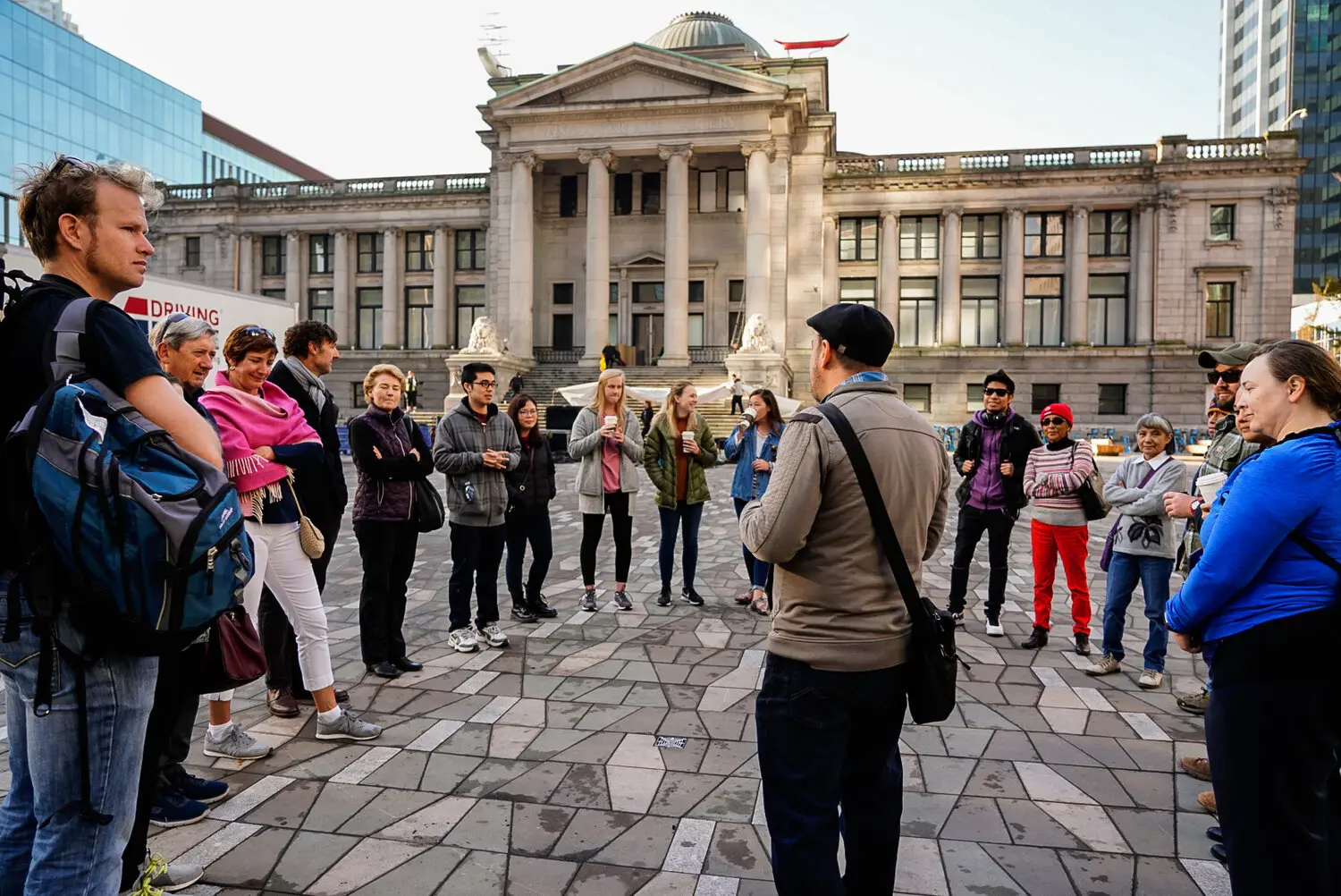 A group listens to a tour guide in front of the Vancouver Art Gallery